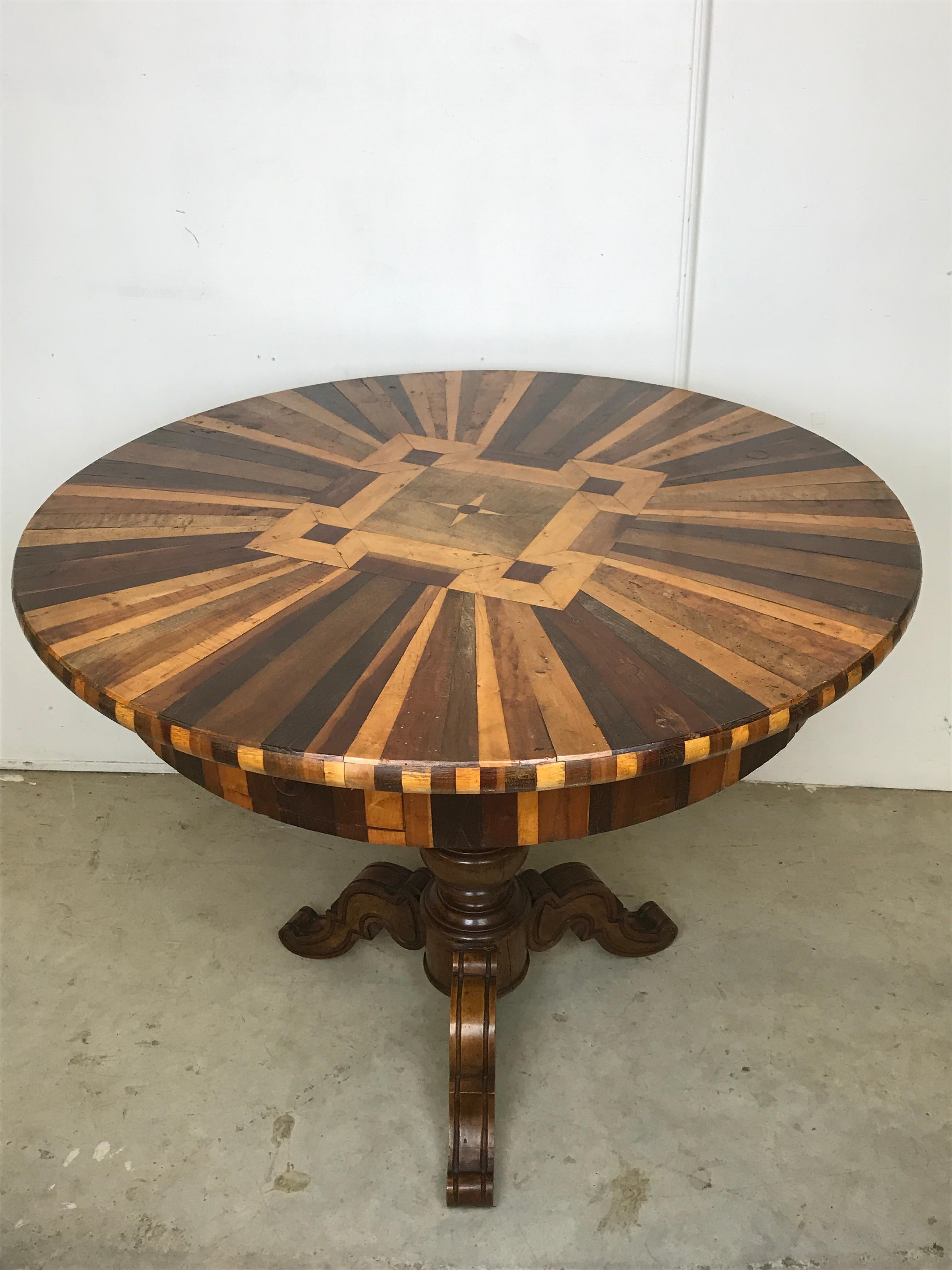 A 19th century French round table, made up of specimen pieces of wood in the top. Some of the timbers used include satinwood, walnut, mahogany, burr ash, elm.