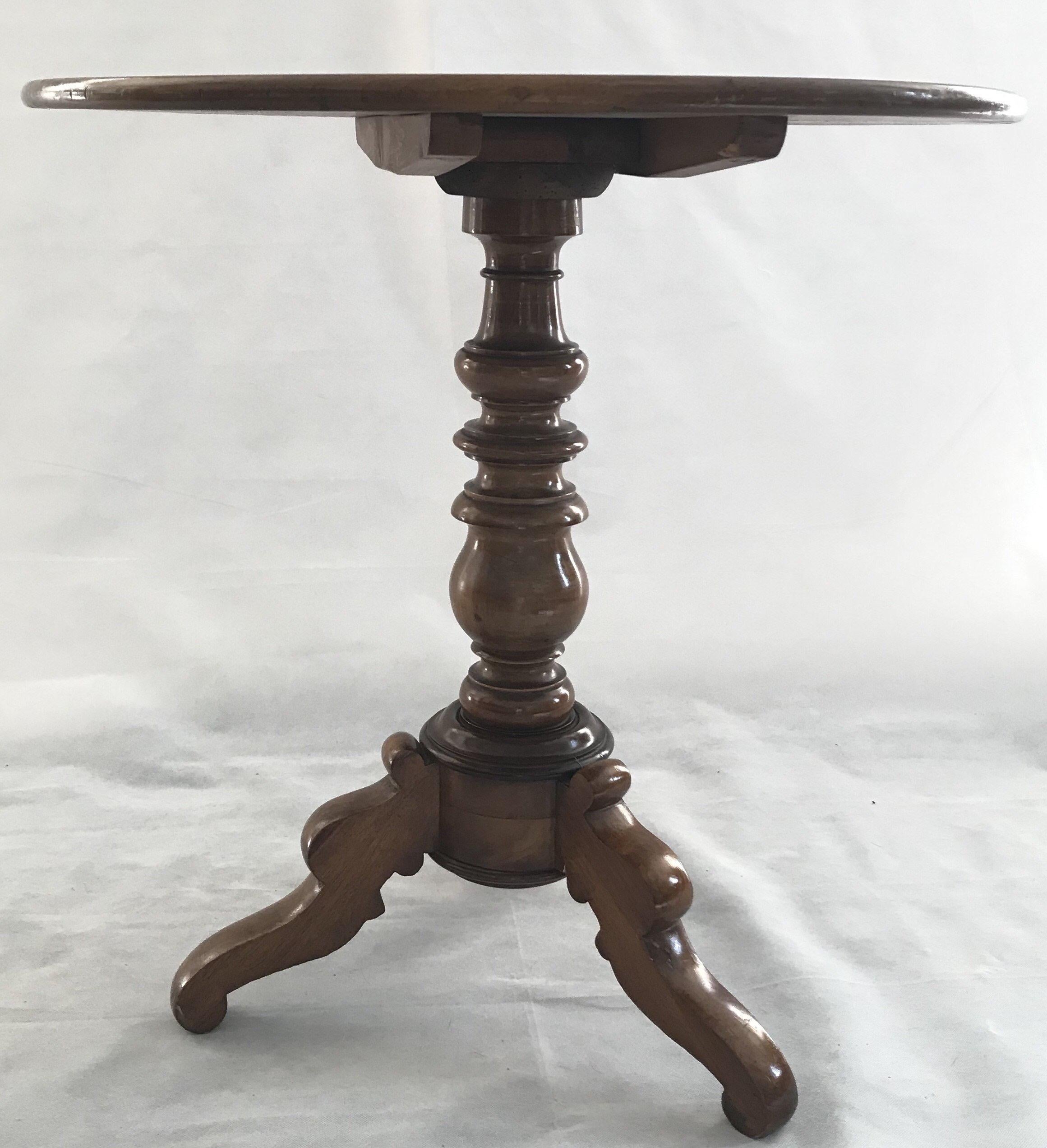 Refined beautifully crafted 19th century French walnut tilt top end table having sumptuously grained walnut, a round top with molded rail, finely carved and turned pedestal with spindled cage and mounted tilting mechanism. The entire affair is