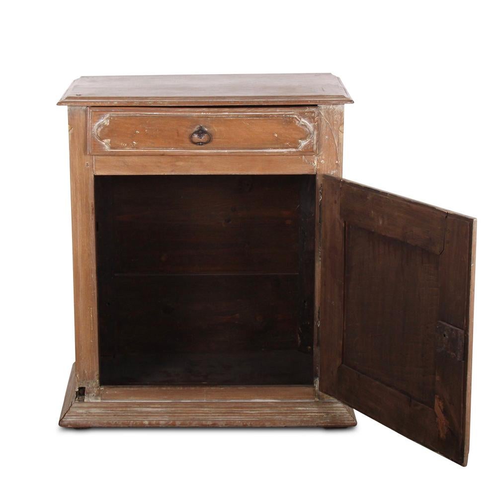 A smaller, French Louis XIII-style cabinet with a single door below a single drawer. Rustic bleached and painted finish accents the bold geometric paneled door. 
From Coco Chanel's Villa la Pausa.

  