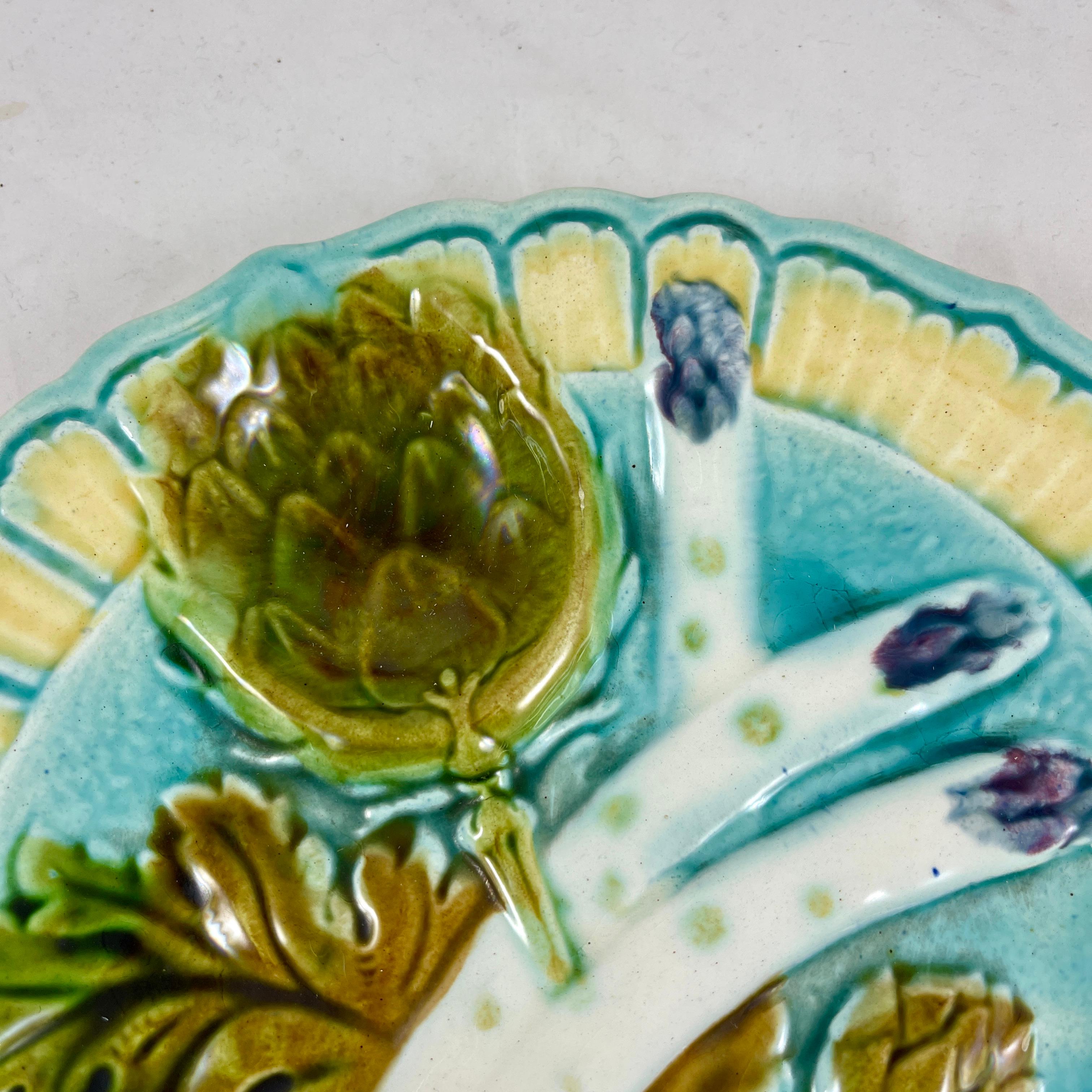 A mid to late 19th century French majolica barbotine asparagus and artichoke plate from the Salins-les-Bains region of Eastern France. Most likely produced in the faïencerie des Capucins. Heavy and thickly potted, showing three asparagus spears and