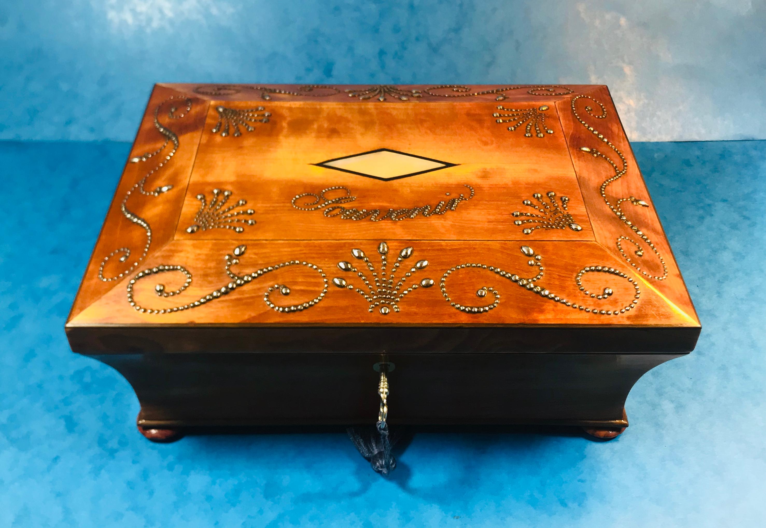 19th century French satinwood jewelry box.
An elegant satinwood box that dates back to circa 1820. There is a steal mounted pattern to the top, spelling out Souvenir in French with a mother of pear escutcheon to the centre. Open the box to reveal