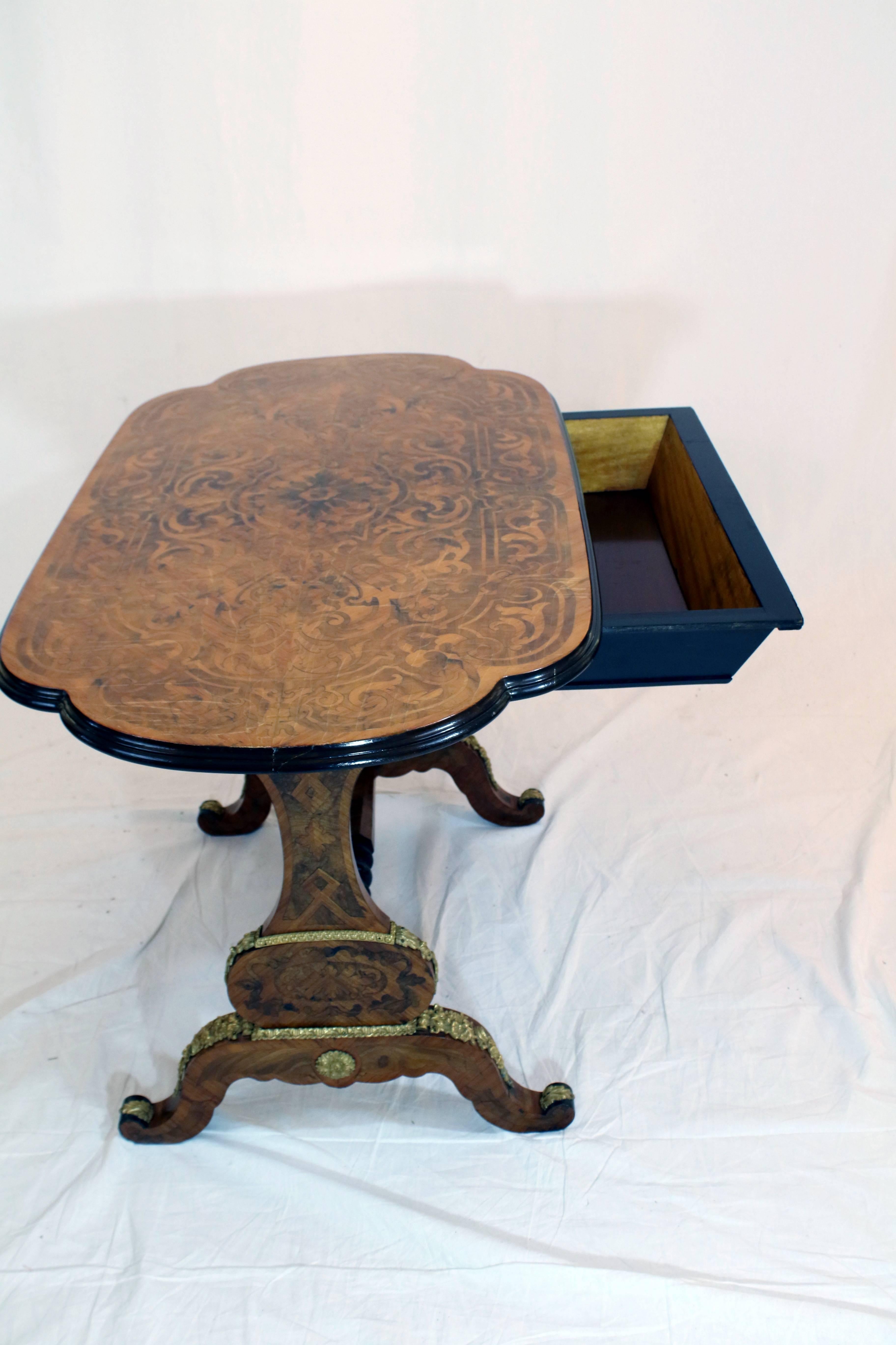 A fine quality 19th century Louis XV style tea table having wonderfully detailed scenes of scrolled foliates to the varnished table top, the interior and exterior sides. A discreet mahogany-lined drawer slides gently on underside wood railing to