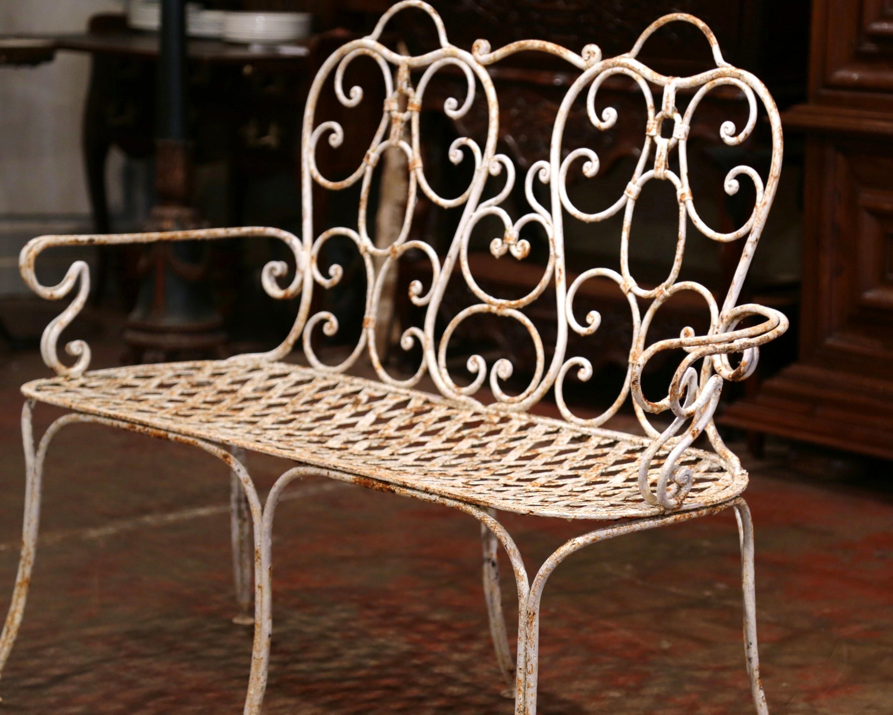 Add extra seating to an outdoor space, porch or patio with this elegant antique iron bench. Crafted in northern France circa 1880, the scrolling bench sits on six thin, curved legs. The delicate garden bench has gracious lines and a beautifully