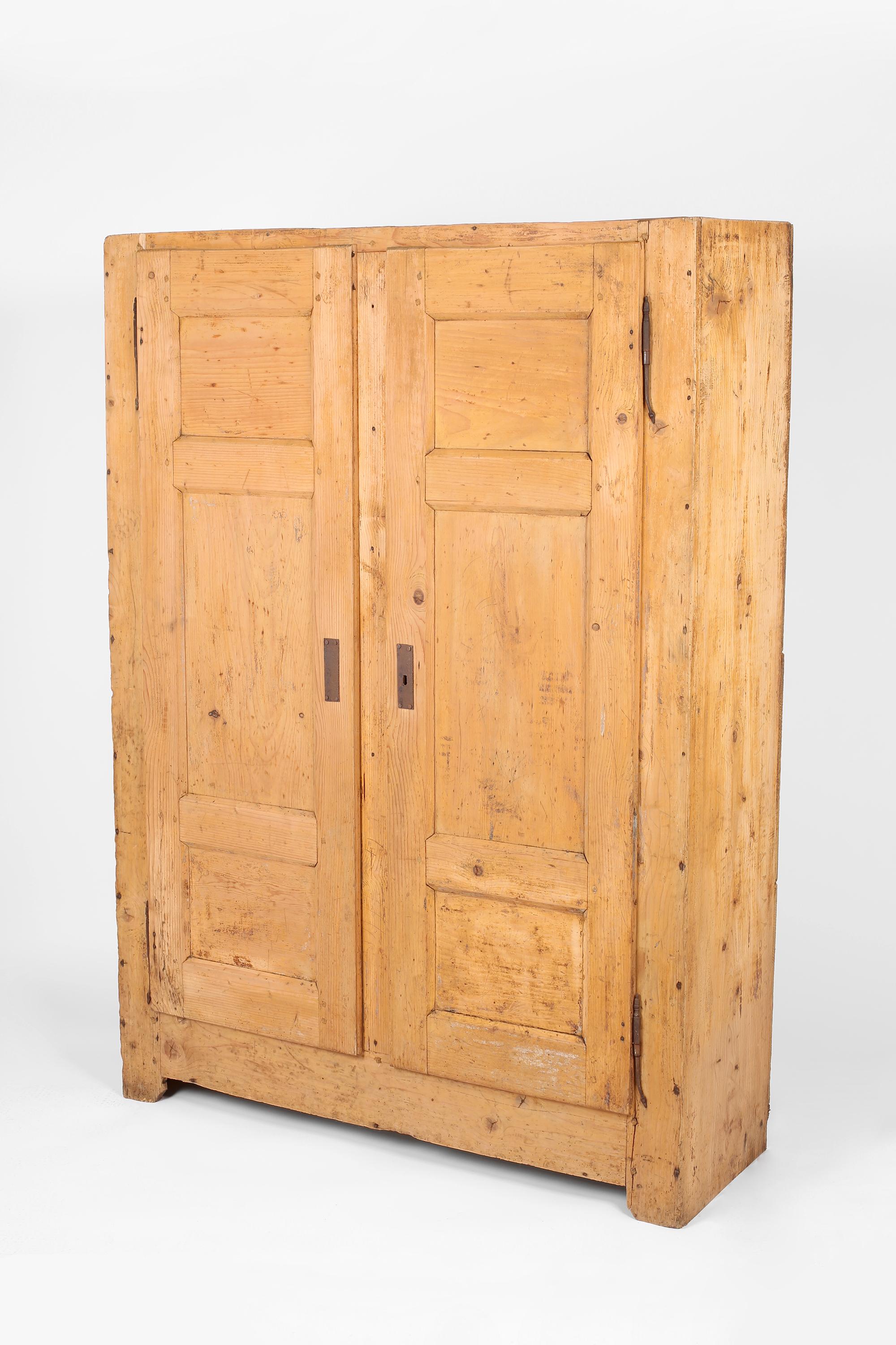 A beautifully patinated 19th century scrubbed pine cupboard from the alpine Haute-Savoie region. Pegged and nailed in construction, with decorative forged iron hinges and original lock with key. Two doors open to reveal a useful arrangement of fixed