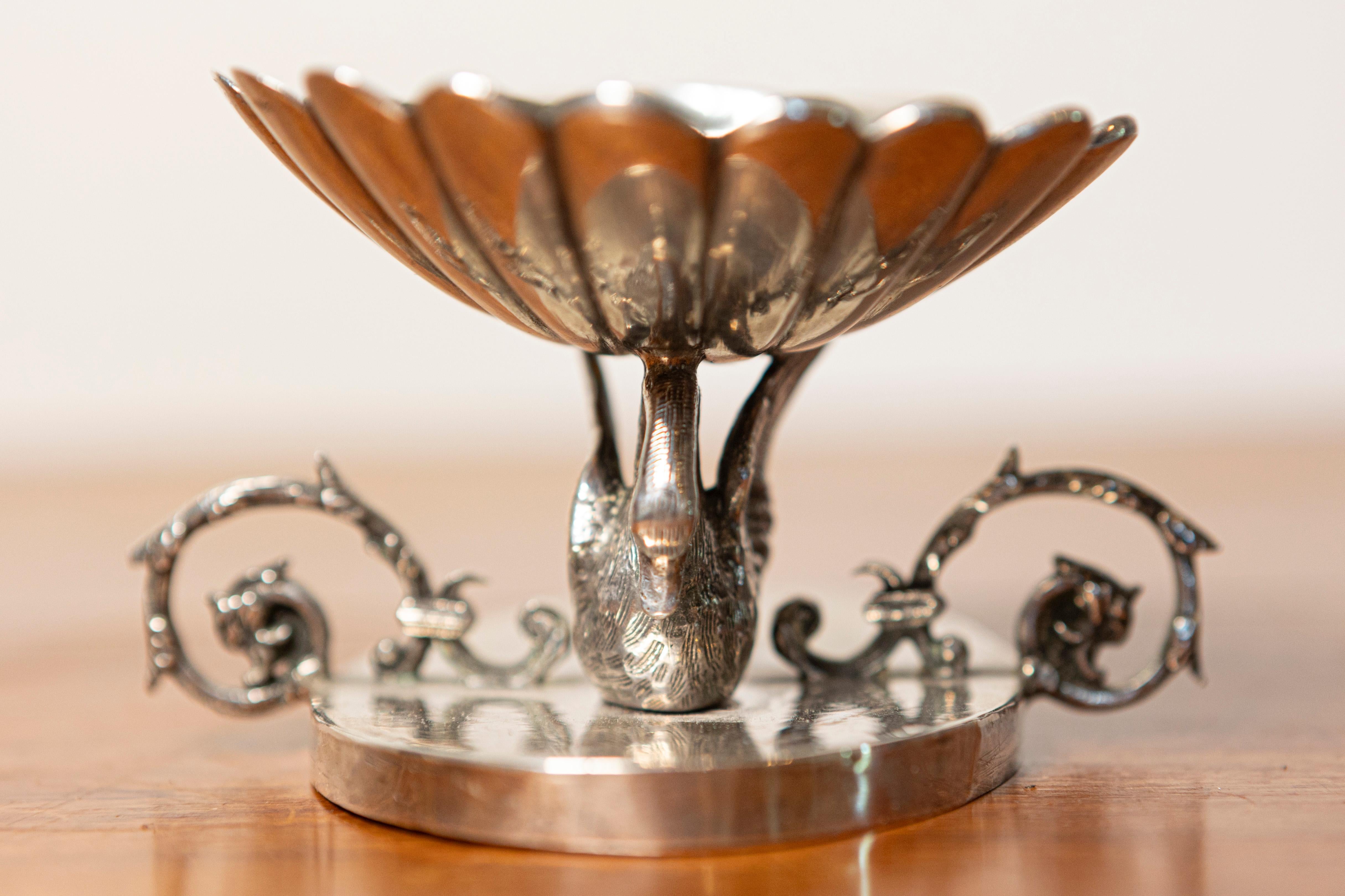 This exquisite 19th-century French silver sculpture is a finely crafted decorative piece featuring an elegant swan motif. The design centers around a gracefully sculpted swan with intricately detailed feathers, serving as the primary support for a