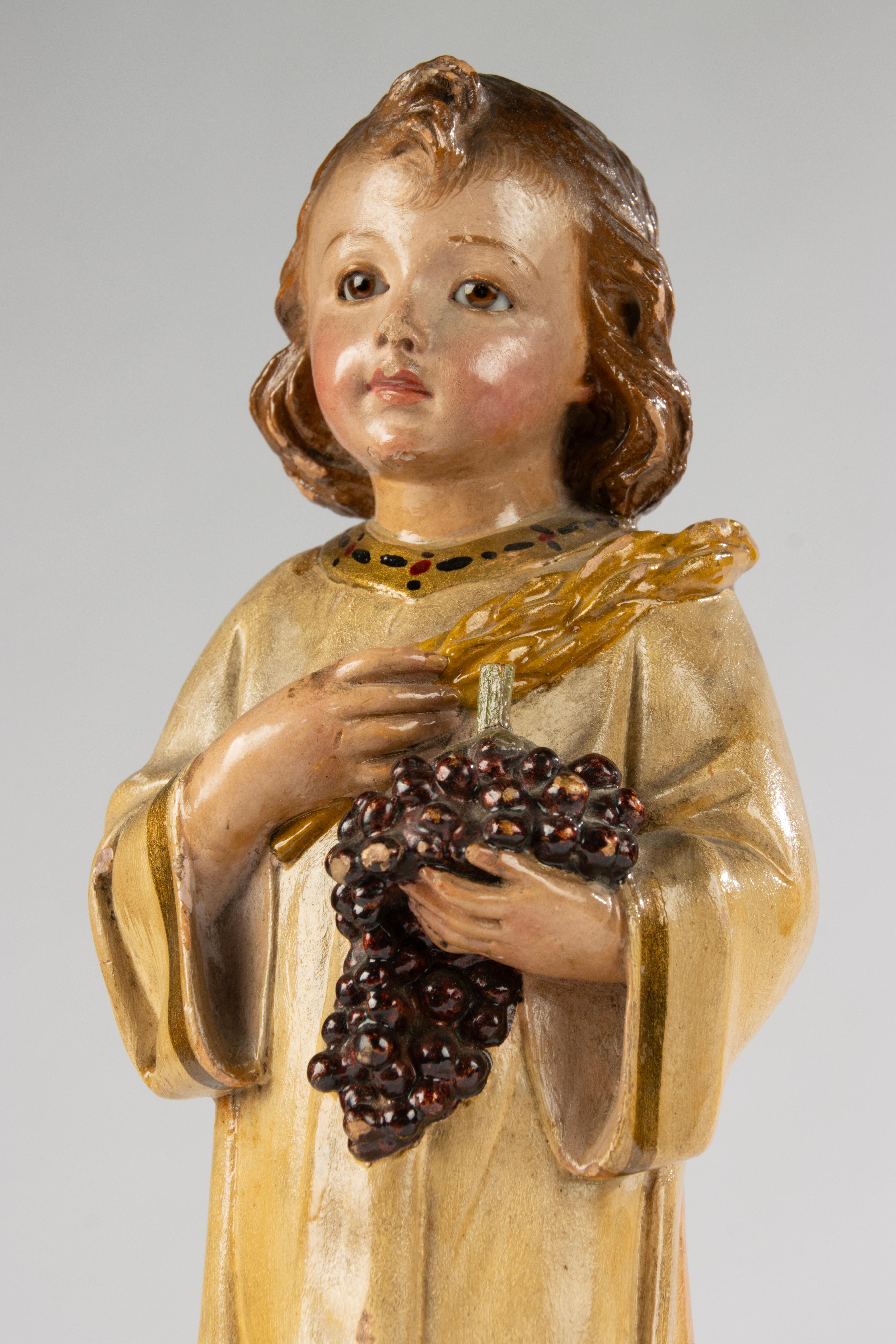 Affascinante scultura del XIX secolo raffigurante il Bambino Gesù, probabilmente di origine francese. La figura è finemente modellata in gesso e montata su una base di legno, con una patina calda e multicolore che ne esalta il carattere devozionale.