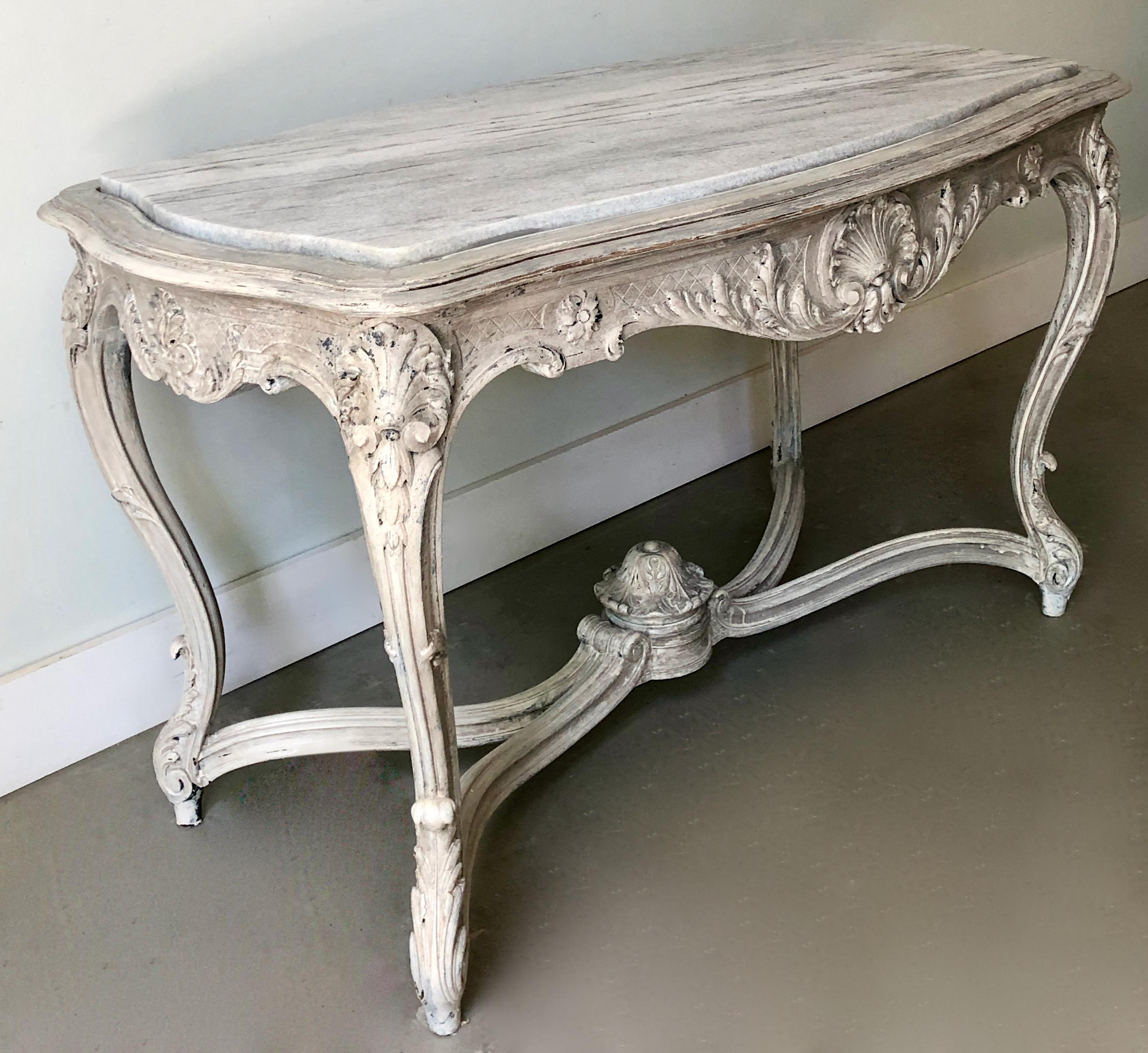 19th century French center table with serpentine shaped inset marble top. Richly carved four sided apron and raised elegant cabriole legs are joined by a shaped stretcher, centered a hand-carved urn finial.
Original broken marble top replaced.
   
