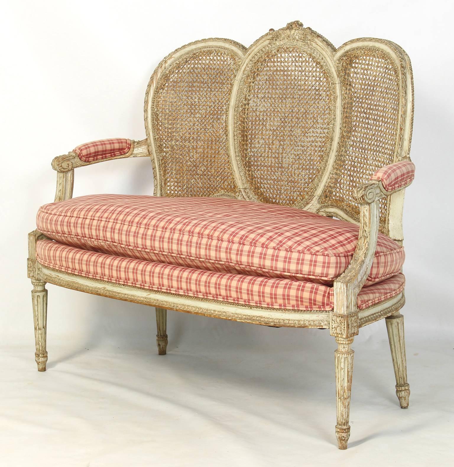 A small and elegant late 19th century. French carved and painted caned back settee with loose down filled cushion.