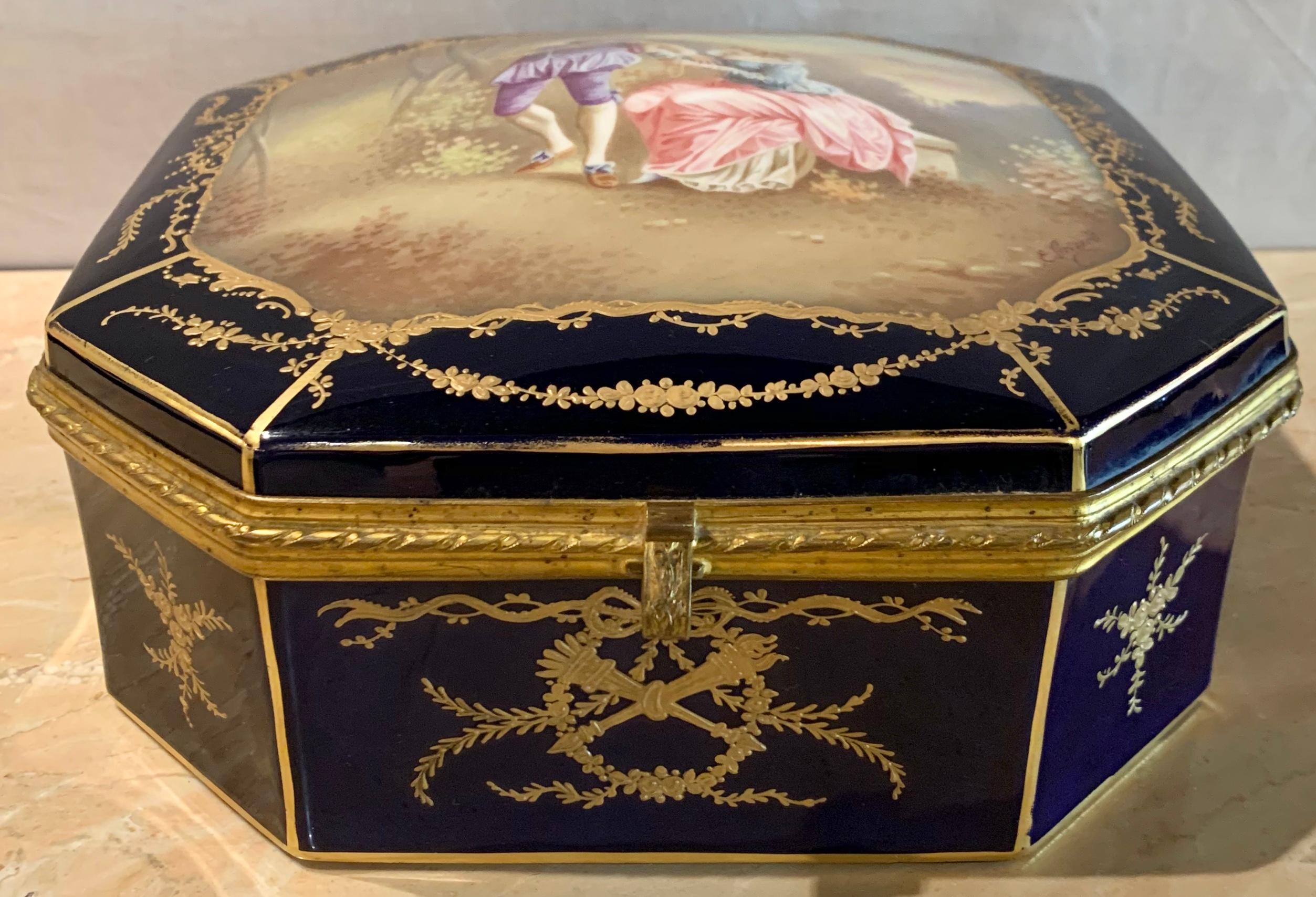 19th century French Sevres cobalt porcelain and gilt bronze casket jewelry box. The cobalt blue porcelain and gilt bronze casket or jewelry box is simply stunning with hand painted courting scene to cover, signed E. Grisard.
The interior having