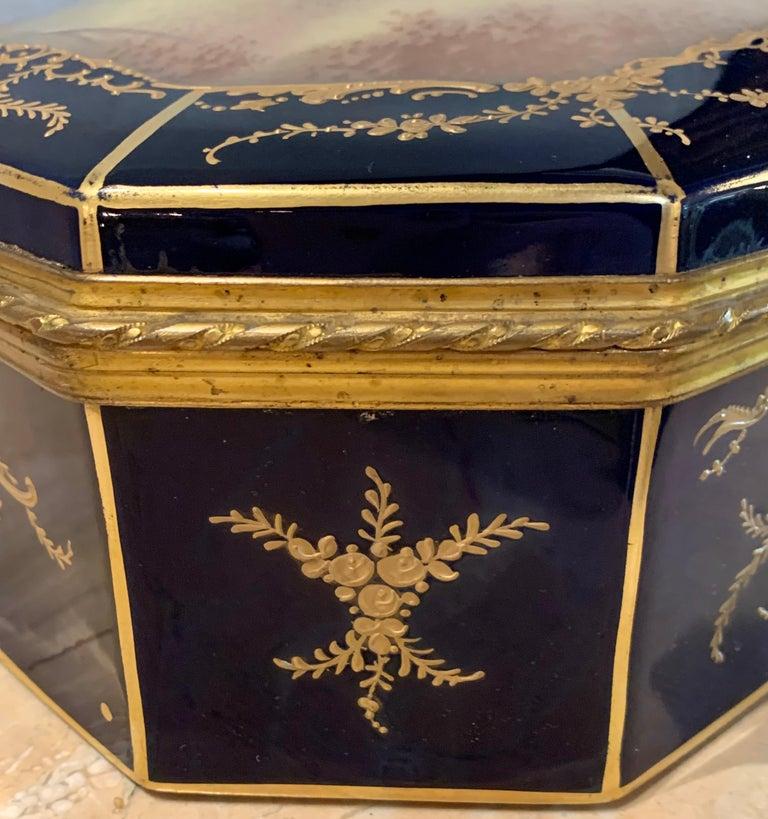 19th century French Sevres cobalt porcelain and gilt bronze casket jewelry box. The cobalt blue porcelain and gilt bronze casket or jewelry box is simply stunning with hand painted courting scene to cover, signed E. Grisard.
The interior having hand