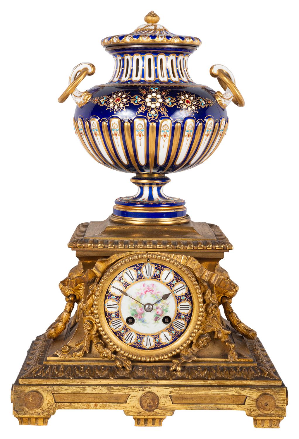 A very good quality late 19th century French gilded ormolu and Sevres style porcelain clock garniture.
The clock having this wonderful cobalt blue ground fluted, lidded vase with ring drop handles and classical motif decoration. Above a porcelain