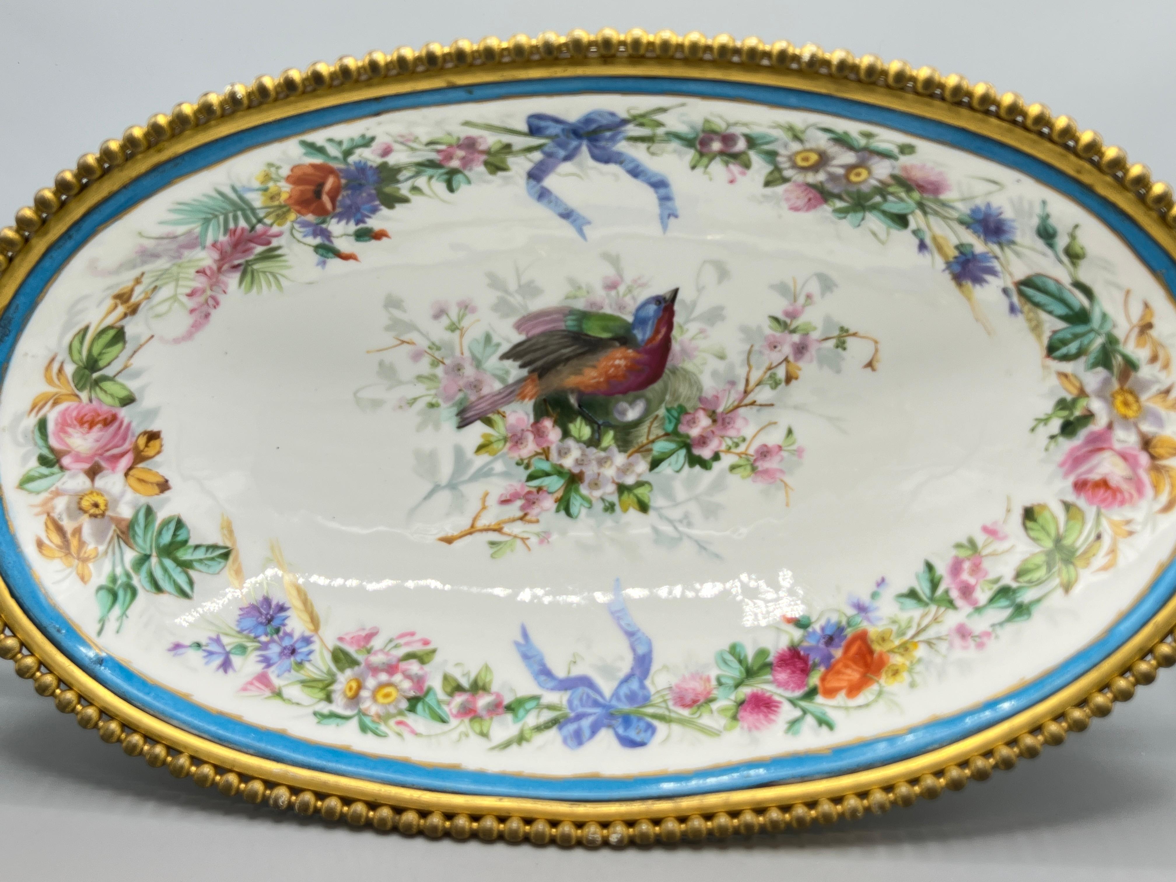Finest quality Antique (late 19th century) French oval-shaped centerpiece bowl in the Sevres style, of impressive scale, measuring 21 3/4 inches across, finely painted and gilt with oval-shaped cartouches depicting courting lovers on one side, and a