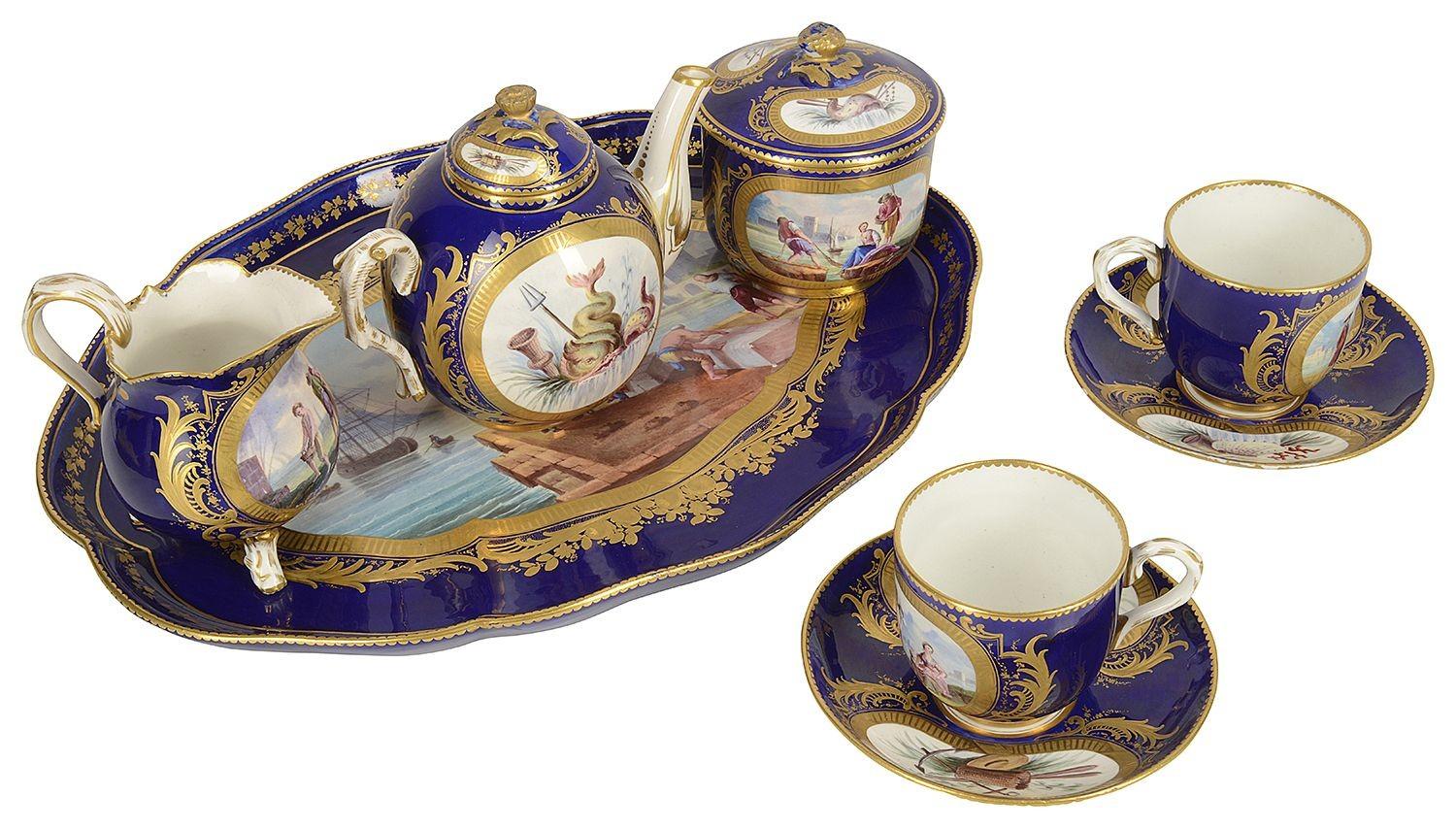 A very good quality late 19th Century French 'Sevres' style porcelain cabaret set. Consisting on a tea pot, sugar bowl, milk jug and two cups and saucers. Each with the classical Cobalt blue ground with inset hand painted scenes of a harbour and