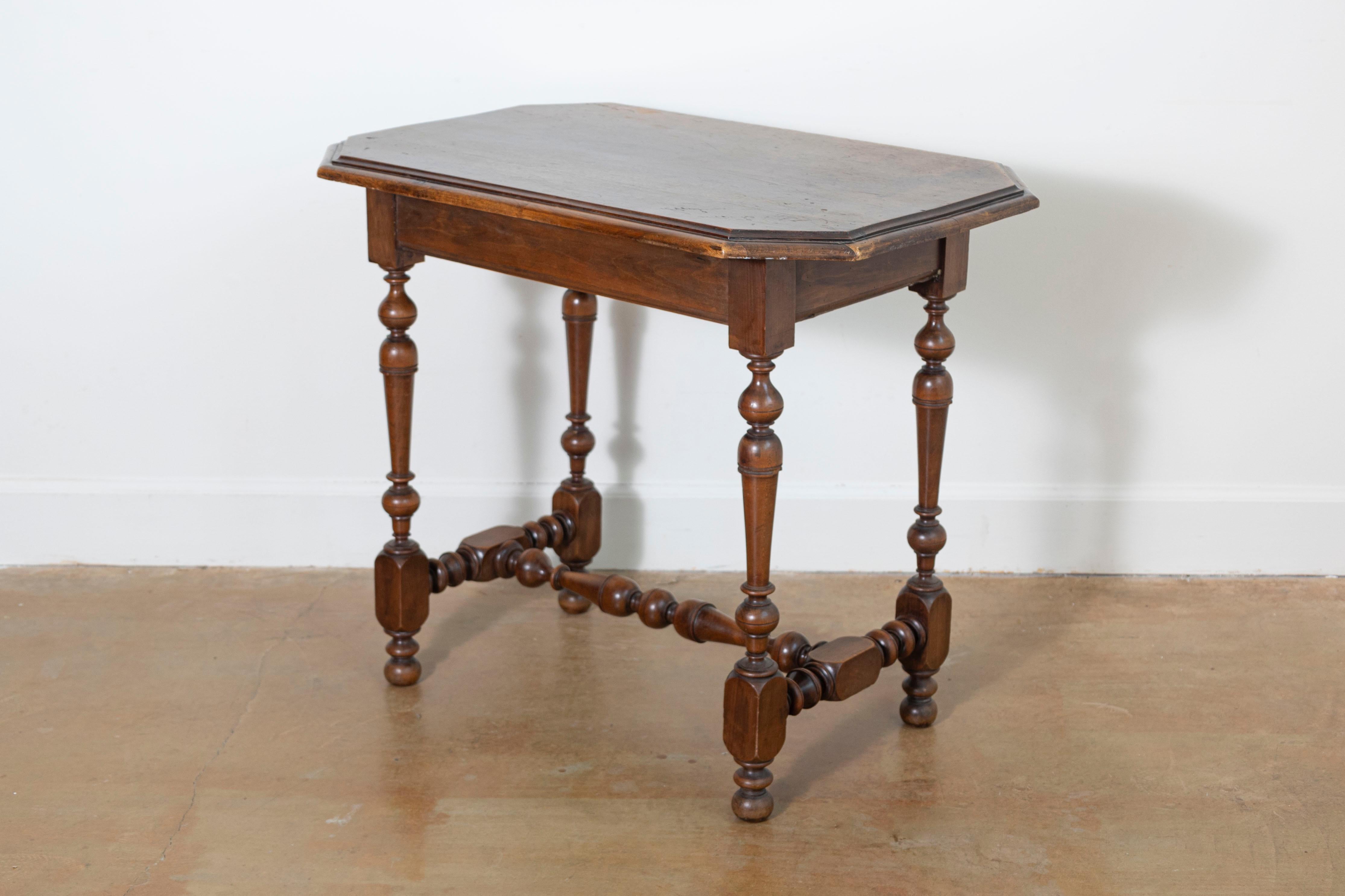 Charmante table d'appoint française du XIXe siècle en bois massif, qui témoigne du savoir-faire et du style de l'époque. La table est dotée d'un plateau rectangulaire de belle forme avec des coins légèrement chanfreinés, soulignant son design à la