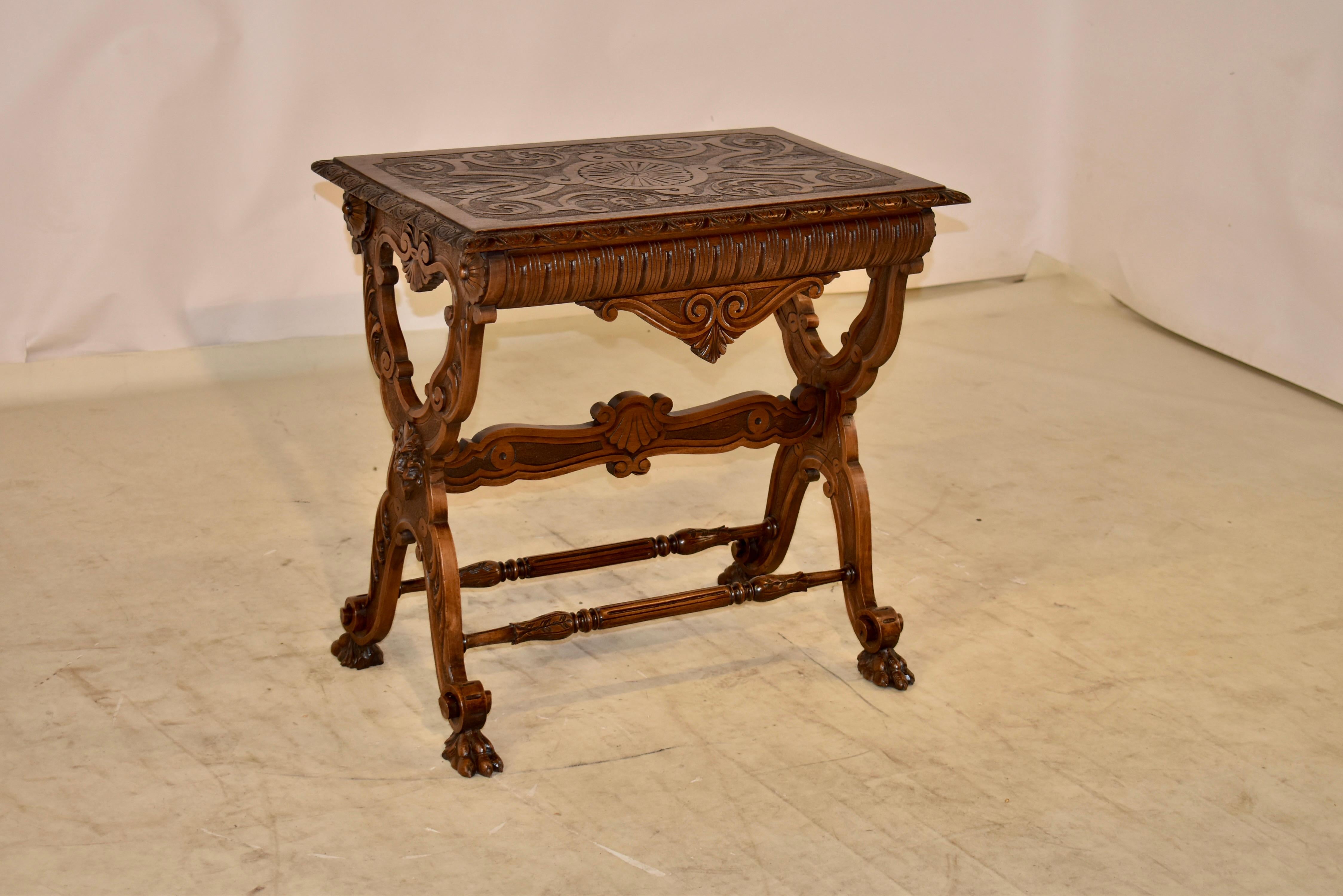 19th century oak side table from France, with a beveled and hand carved decorated edge around the top, surrounding an exquisitely hand carved central scene, depicting scrolls, acanthus leaves and a central circular design. The top is supported on