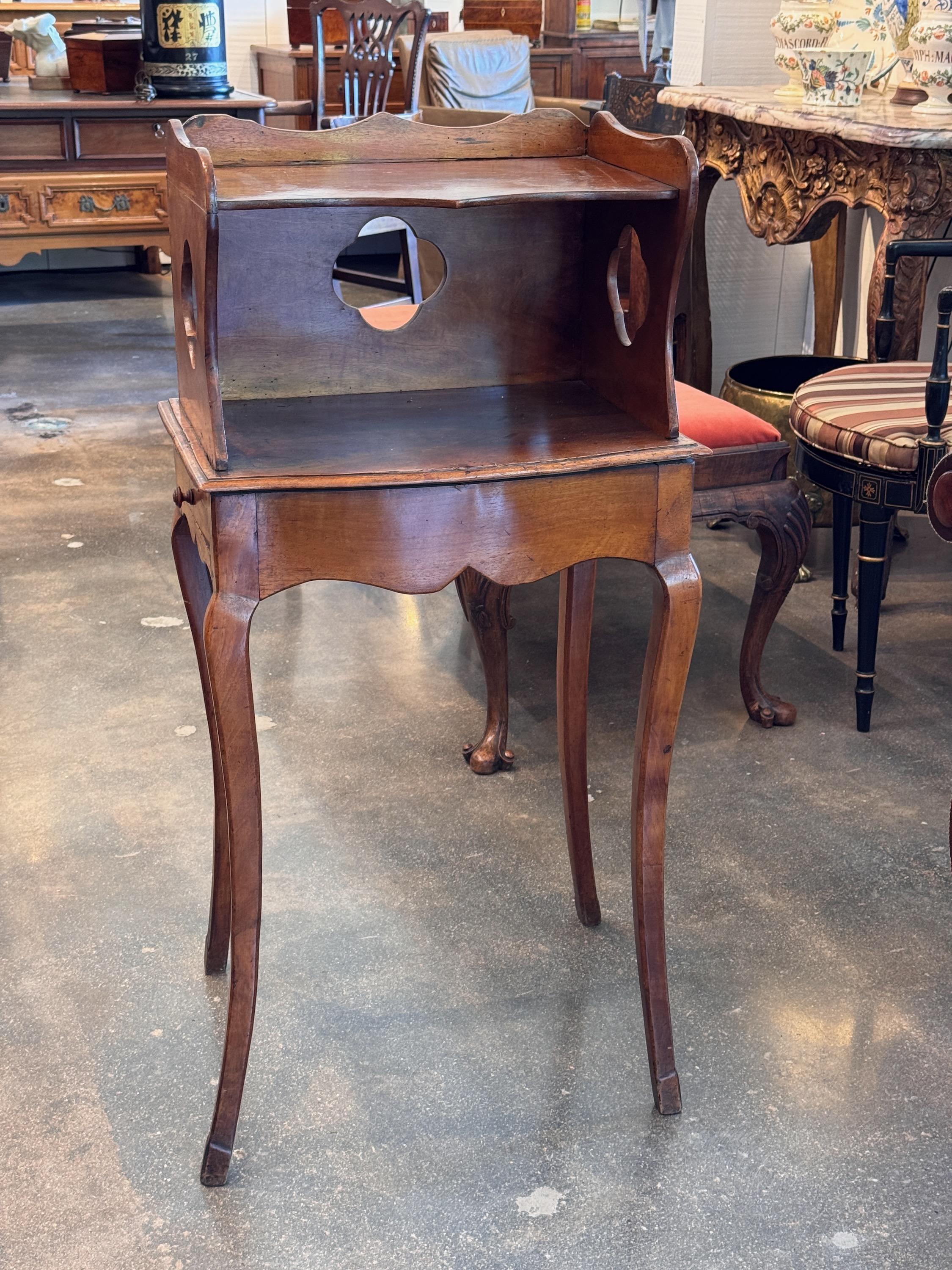 Charmante table d'appoint française du 19e siècle avec un meuble supérieur présentant des découpes quadrilobées et circulaires. Le tablier façonné et les pieds cabriole lui confèrent une silhouette légère et élégante, tandis que la menuiserie à