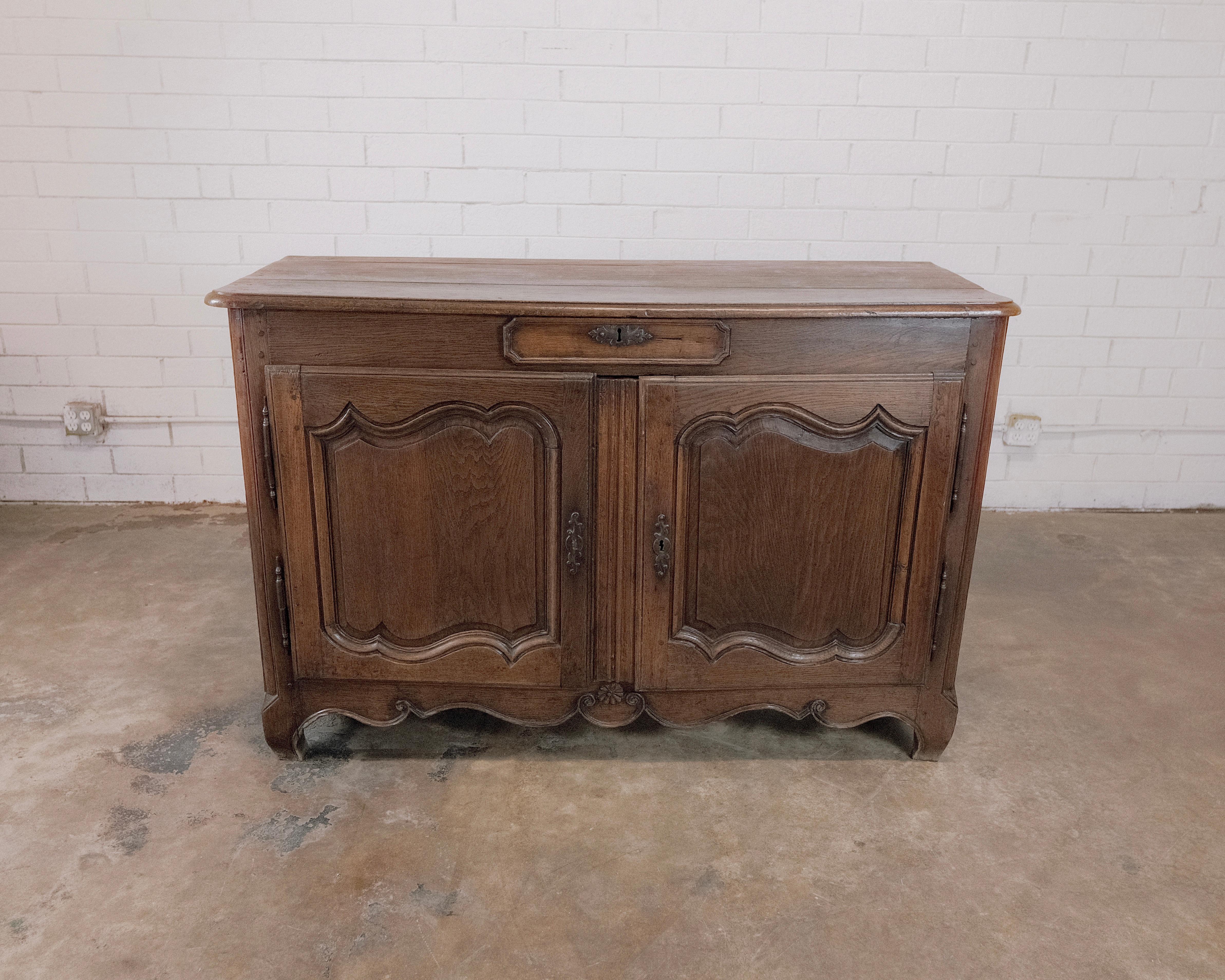 Experience the grace and heritage of the 19th Century with this exquisite French Sideboard, featuring two cabinets and a central drawer. Crafted with meticulous attention to detail, this piece is a true embodiment of the elegance and functionality