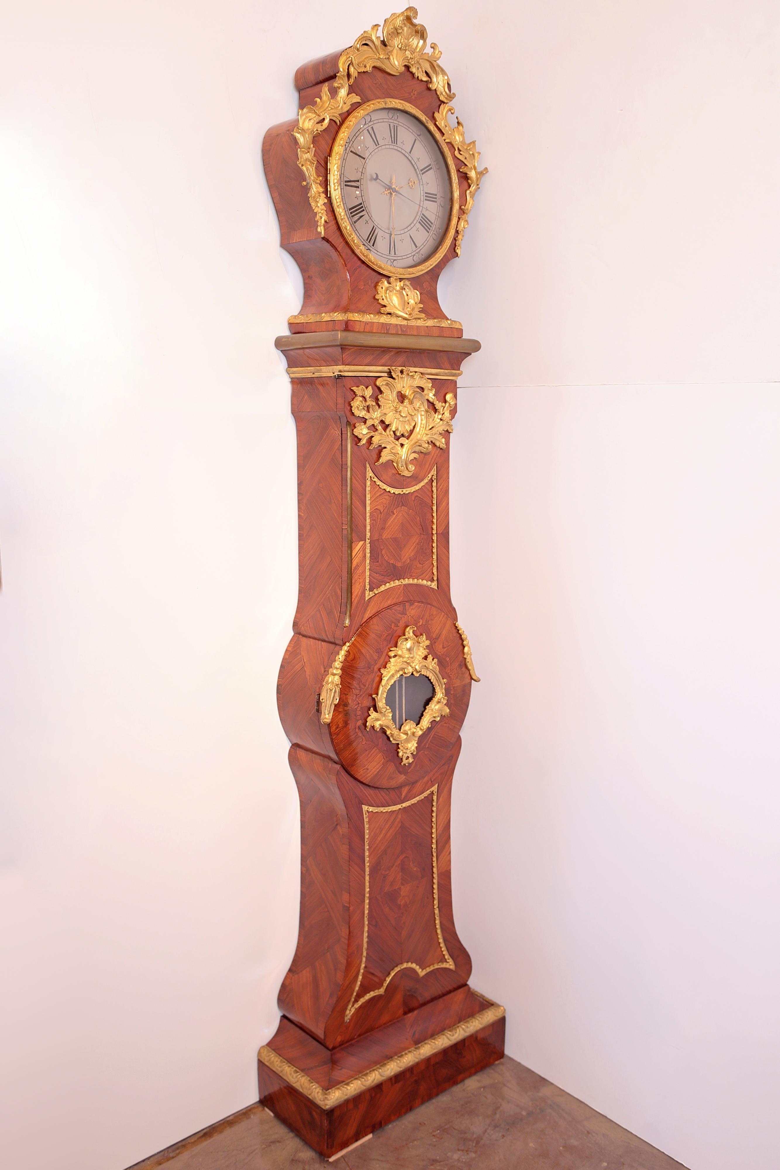 Louis XV style gilt-bronze mounted tall case clock
The circular silvered dial with block roman and Arabic numerals, above the elongated designed rosewood case with hinged door.
 