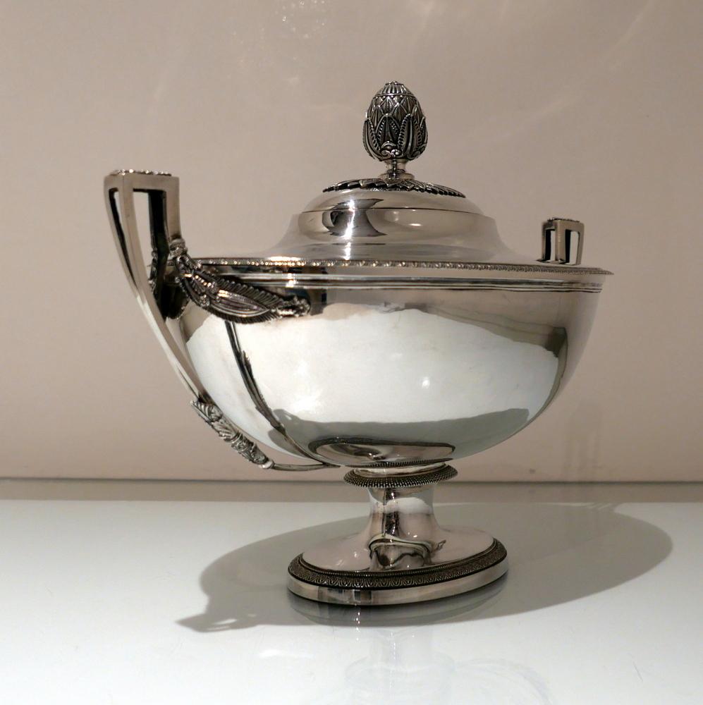 A large oval and incredibly fine French silver “Empire” soup tureen and cover, plain formed in overall design however featuring beautifully ornate mounts and handles for decorative contrast. The detachable domed lid has a sumptuous handle for