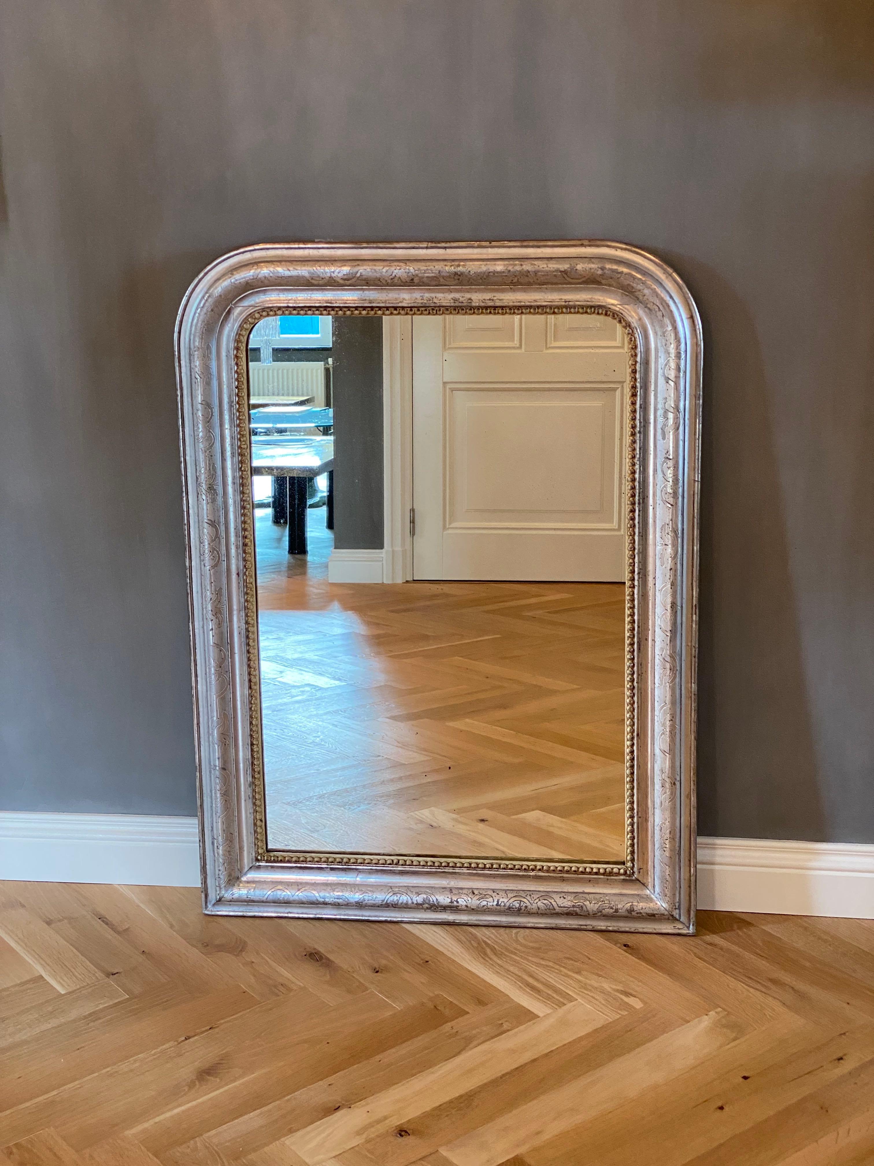 A pretty 19th century French mirror Louis-Philippe with its original antique glass and silver leaf gilding.
The frame is etched with foliate motifs and has a beaded edge.
The mirror has an original wooden back.