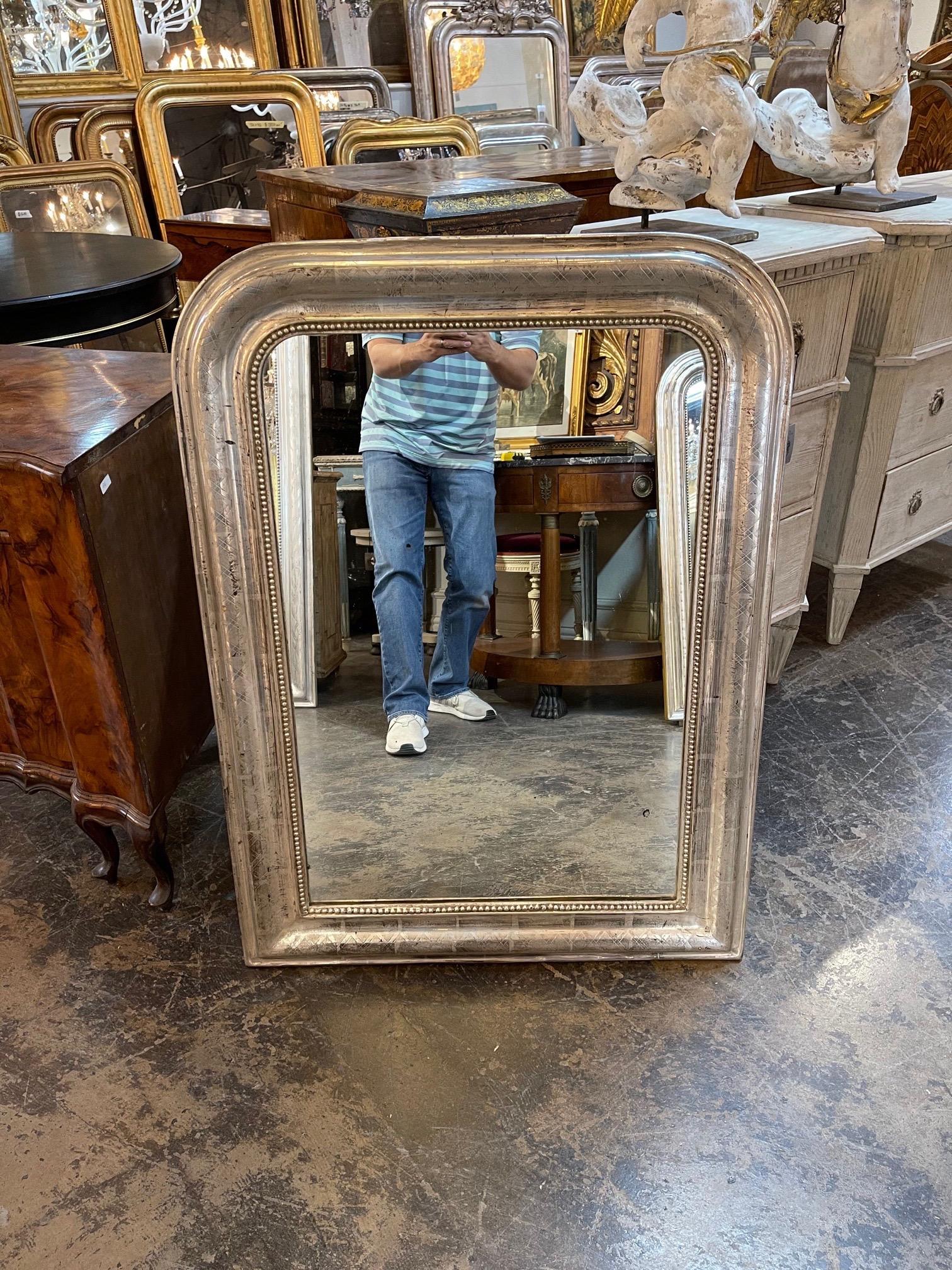Elegant 19th century French silver leaf Louis Philippe mirror. The piece has a decorative X-pattern and a beaded inner edge. Lovely!