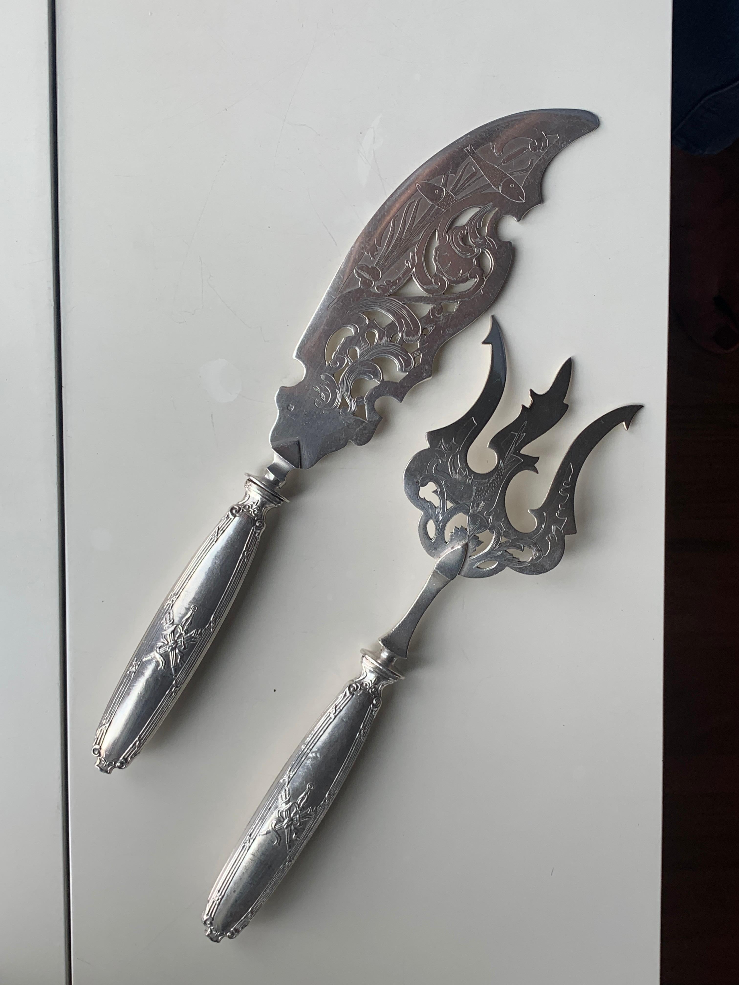 Set da portata in argento con manici decorati con torce e faretra inscritta in una cornice di reti e nastri incrociati. La lama e la forcella traforata sono decorate con pesci e piante marine.
Peso lordo: 222,95 g
Francia, circa 1880.