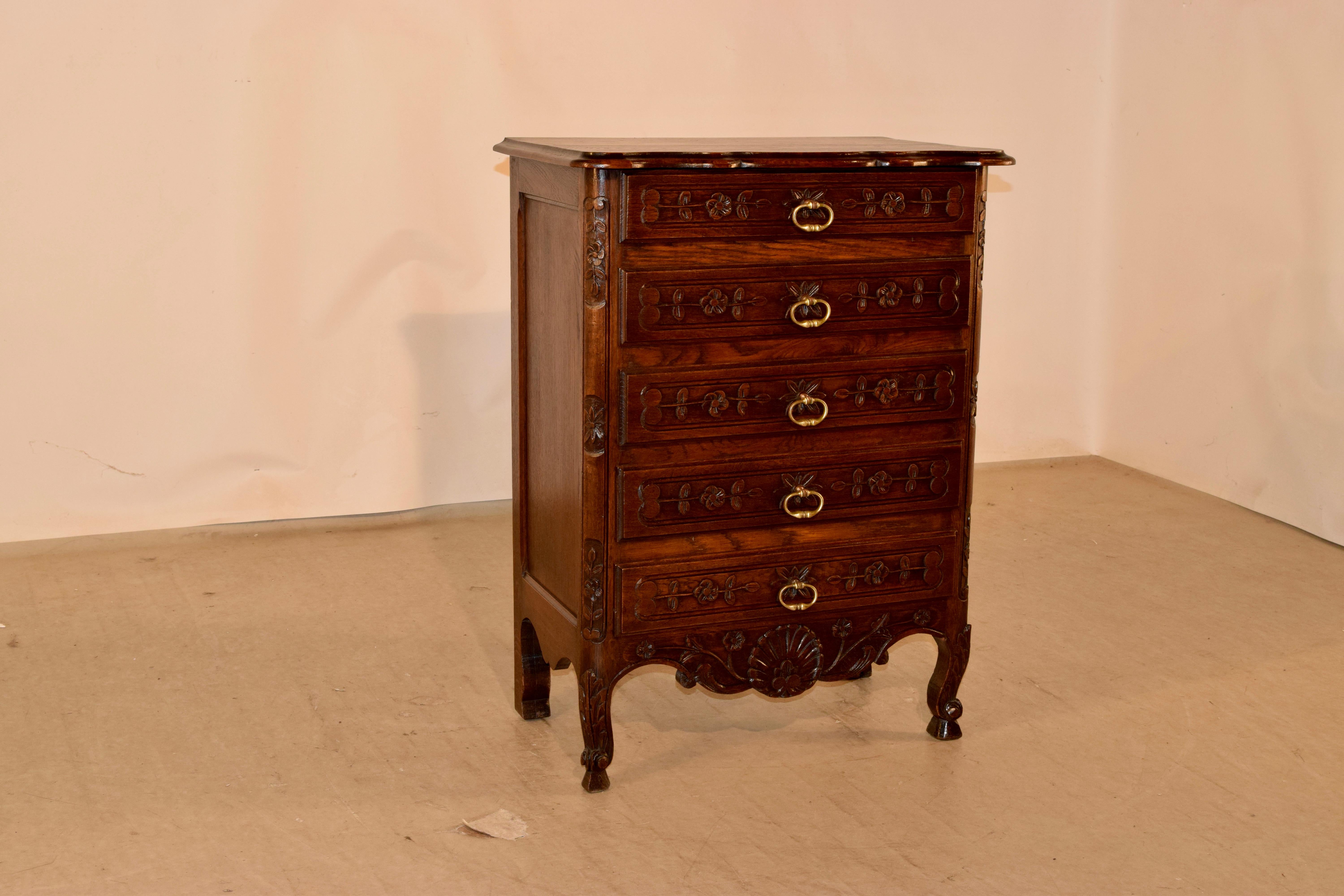 19th century single oak chest of drawers from France. The top is scalloped and has a beveled edge, following down to paneled sides and five drawers in the front, all with carved panels. The drawers are flanked by carved quarter columns. The case is