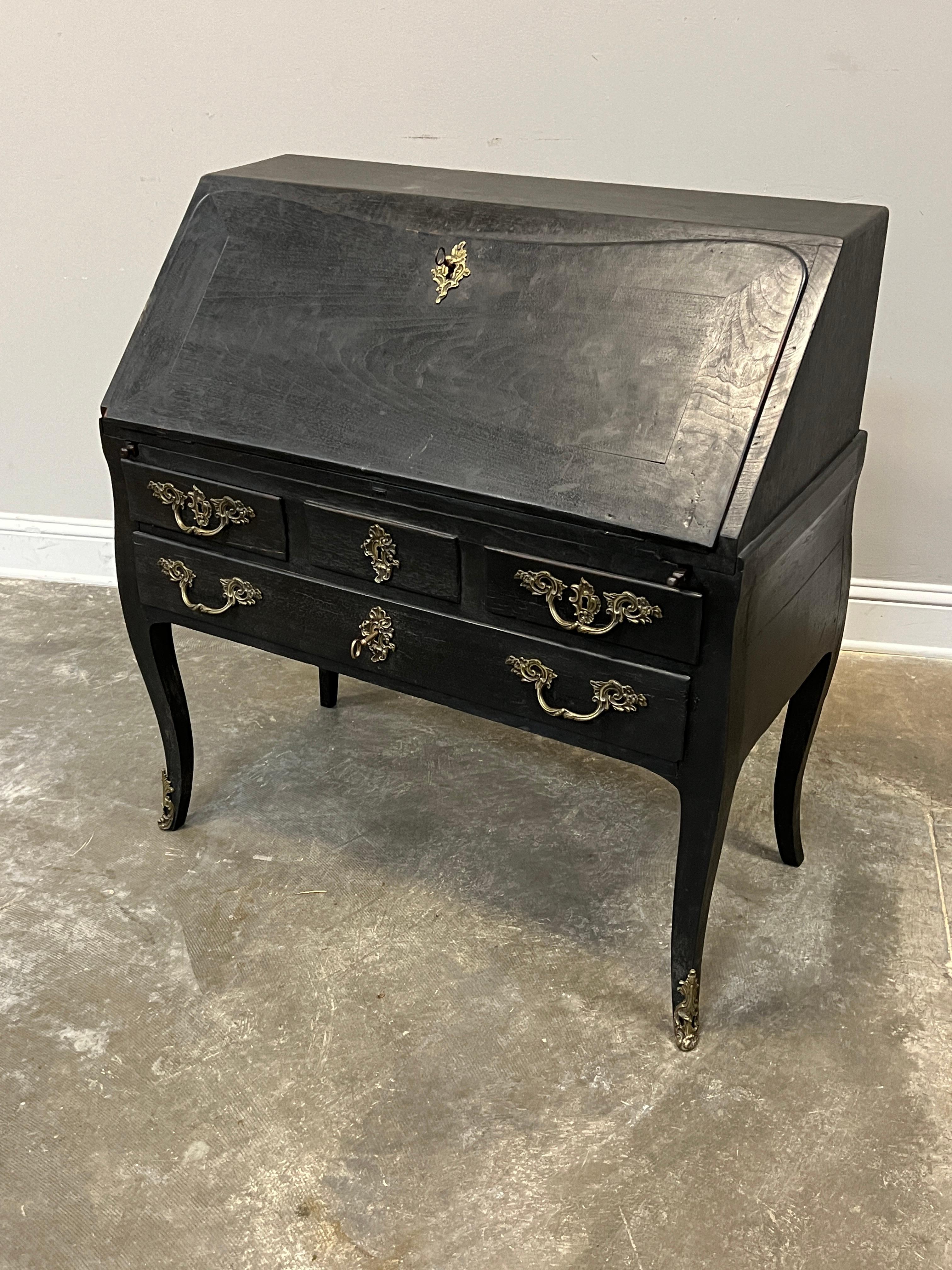 Lovely painted drop leaf or slant front desk made more charming with painted blue interior. Overpainting on the exterior in black. 

Louis XV style with Regence leanings, desk was hand made in early 19th C. French in oak with mortice and tenon and