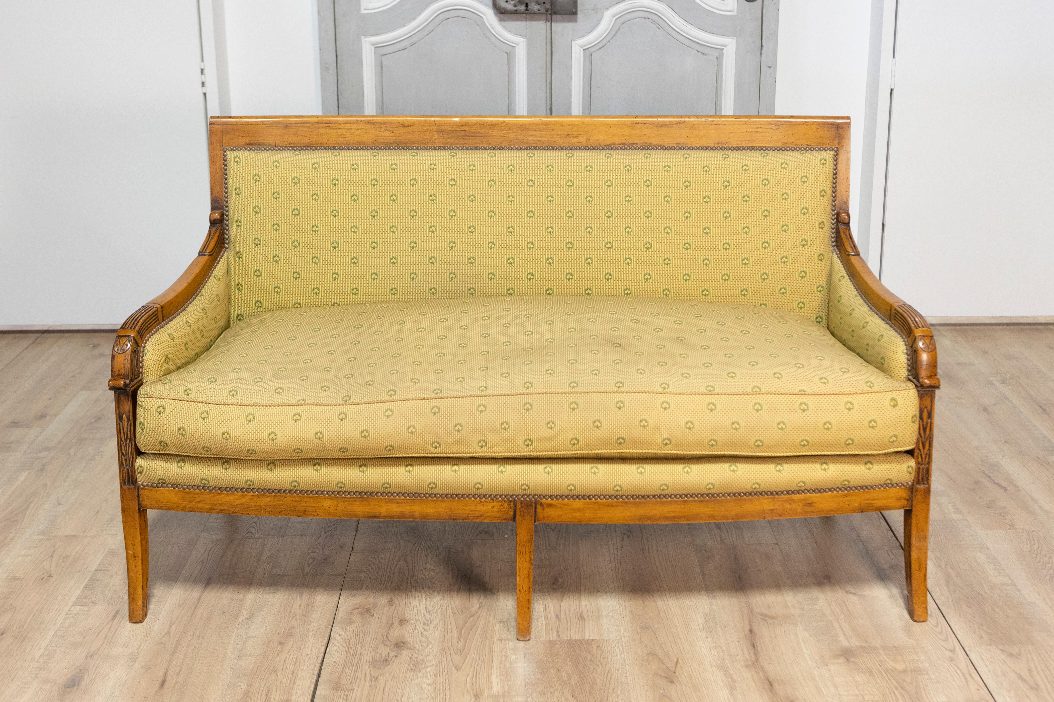 Questo elegante divano francese del XIX secolo è un pezzo magistralmente realizzato che riflette un design senza tempo e una maestria superiore. La struttura in noce presenta intricati intagli lungo i braccioli e lo schienale, mettendo in mostra