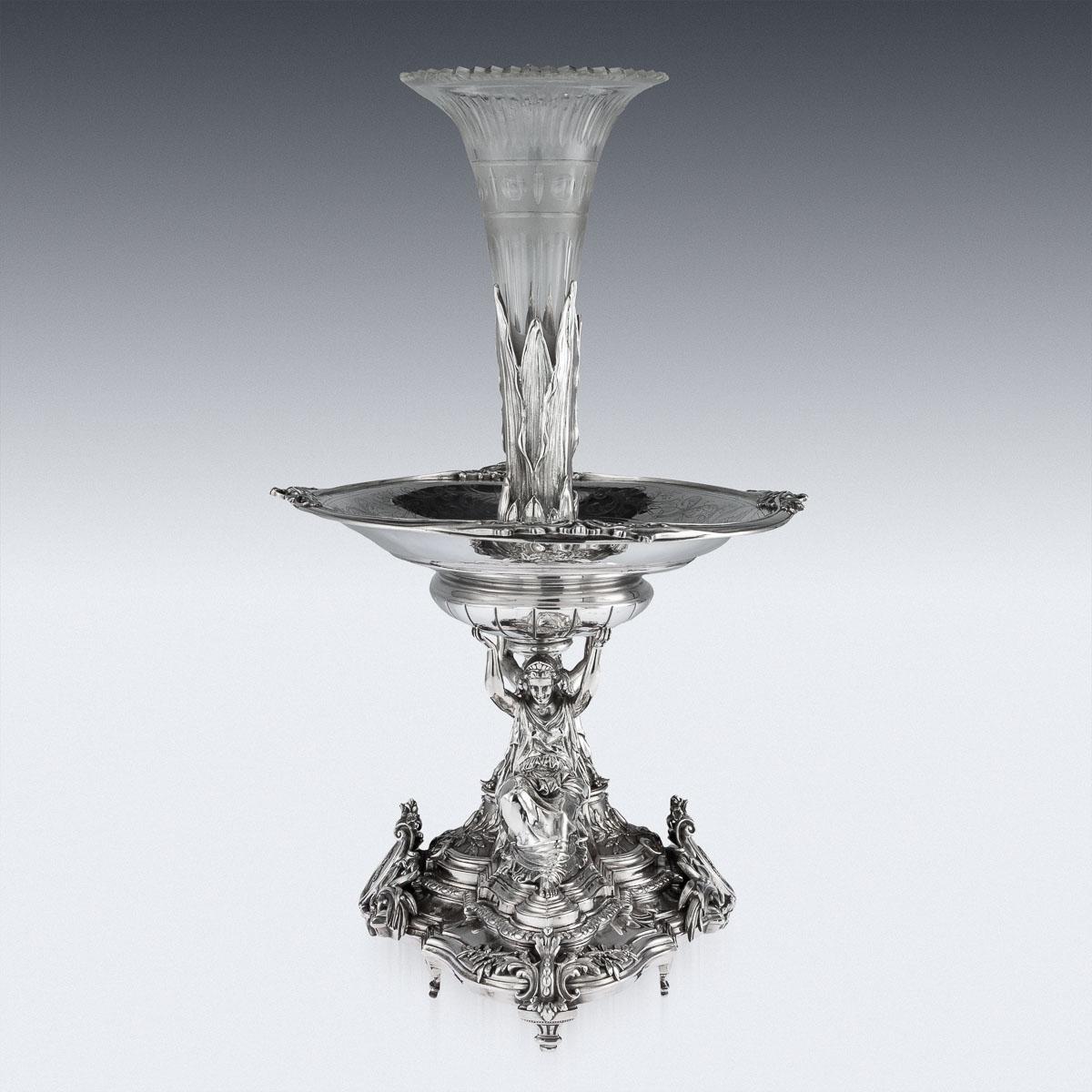 Antique 19th Century French exceptional solid silver figural centerpiece, standing on eight shaped feet, the ornate base is applied with a very crisp scrolling foliate decoration in relief, supporting two large and finely modelled classical female