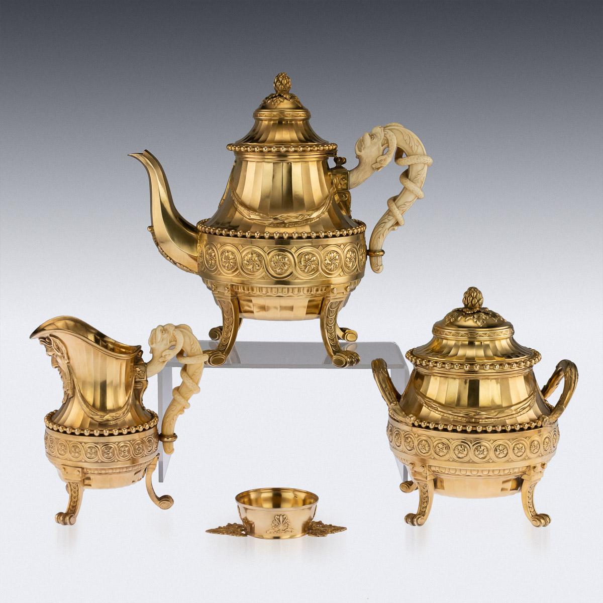 Antique 19th century exceptional French Louis XVI style solid silver-gilt tea service on tray, comprising of a teapot, covered sugar bowl, cream jug, twelve tea cups and a tea stariner, all richly gilt throughout. Tea set standing on cast scroll