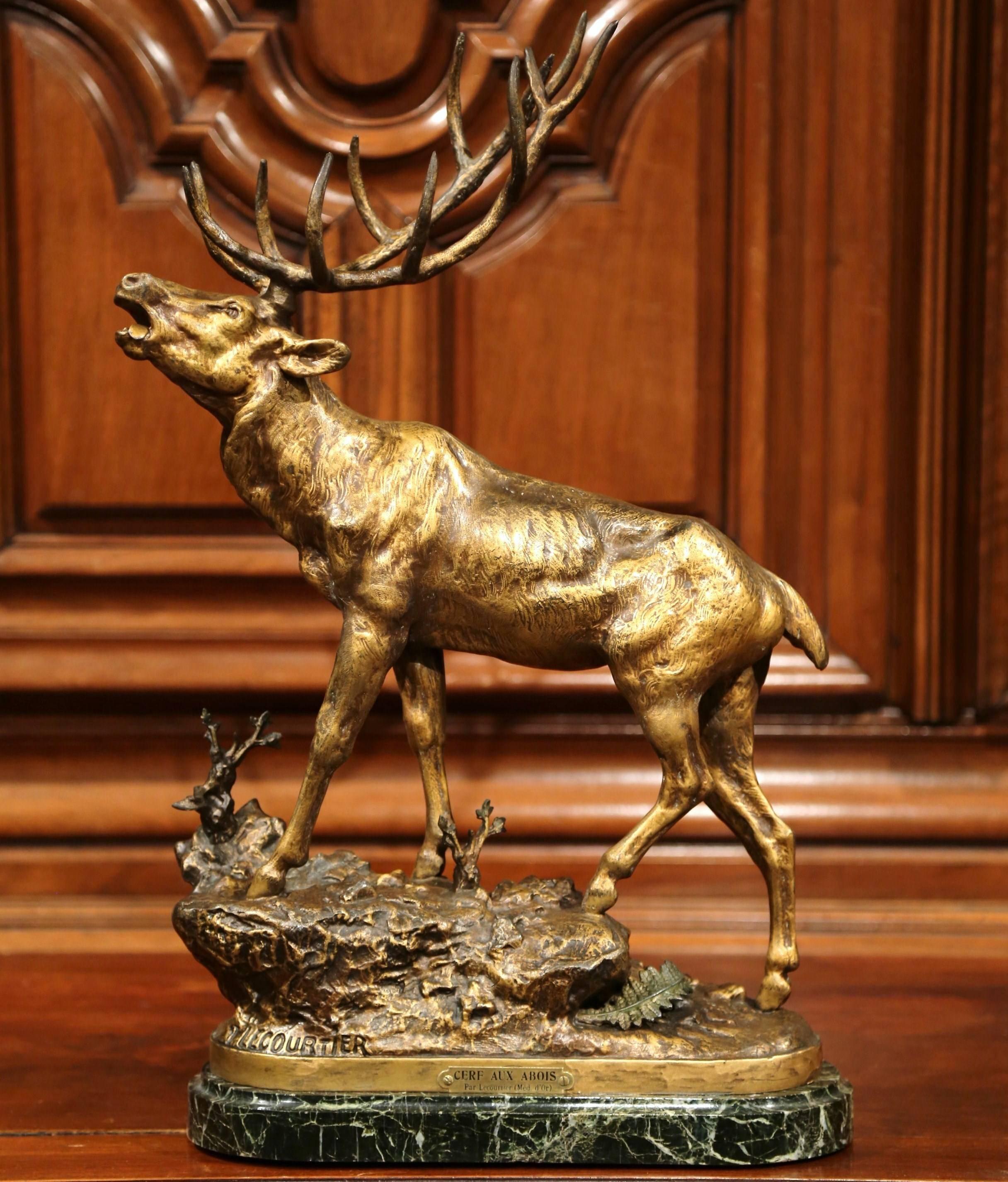 This elegant antique, patinated metal sculpture was created in France, circa 1880. The detailed spelter piece features a realistic deer at bay standing on a black marble top. The large sculpture is signed on the front Lecourtier with a plaque on the