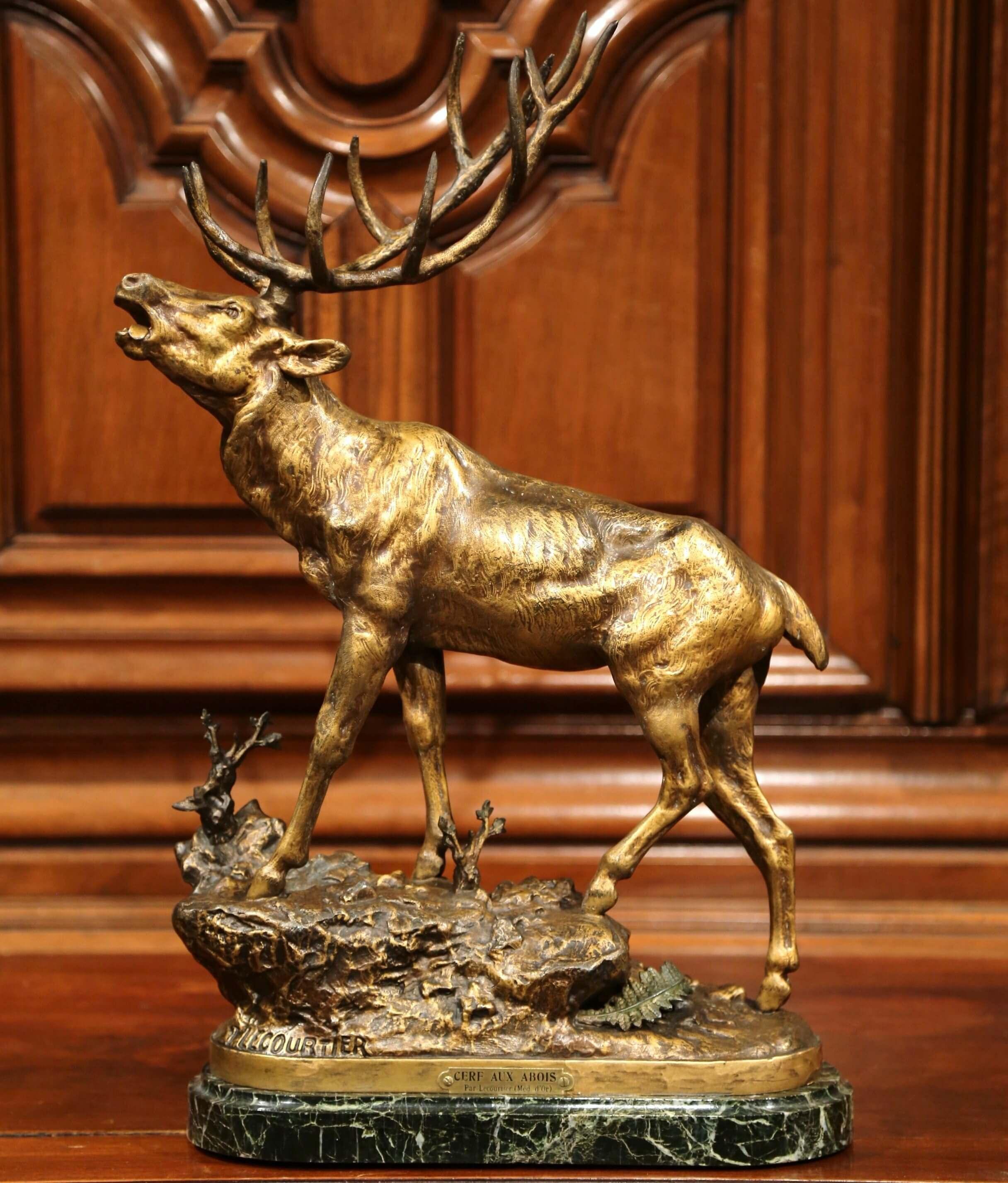 This elegant antique, patinated metal sculpture was created in France, circa 1880. The detailed spelter piece features a realistic deer at bay standing on a black marble top. The large sculpture is signed on the front Lecourtier with a plaque on the