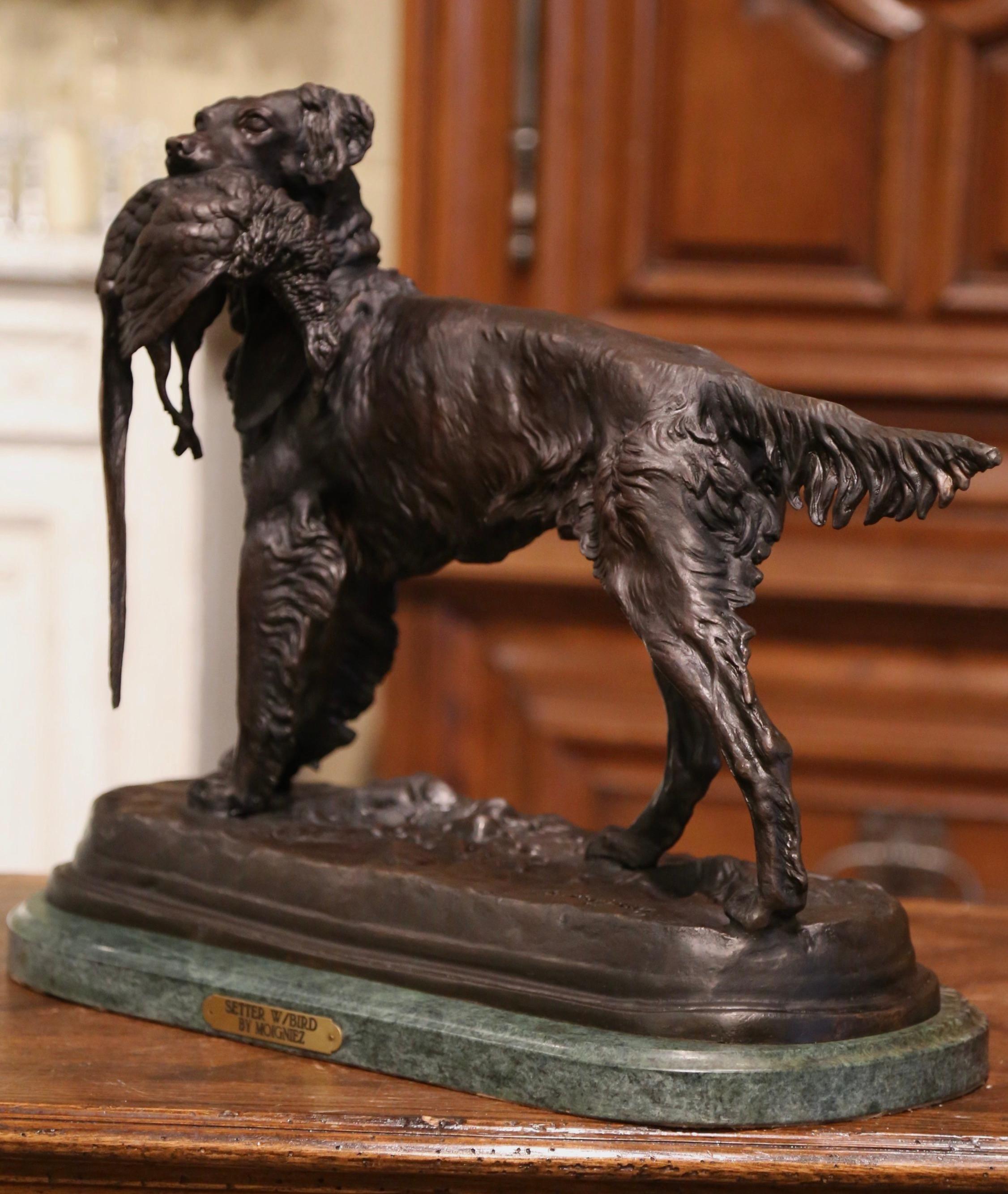 Decorate a man's office or library with this antique dog and bird sculpture. Created in France circa 1870, and standing on a newer oval green marble base, the sculpture composition depicts a hunting setter holding a pheasant in his mouth. The large