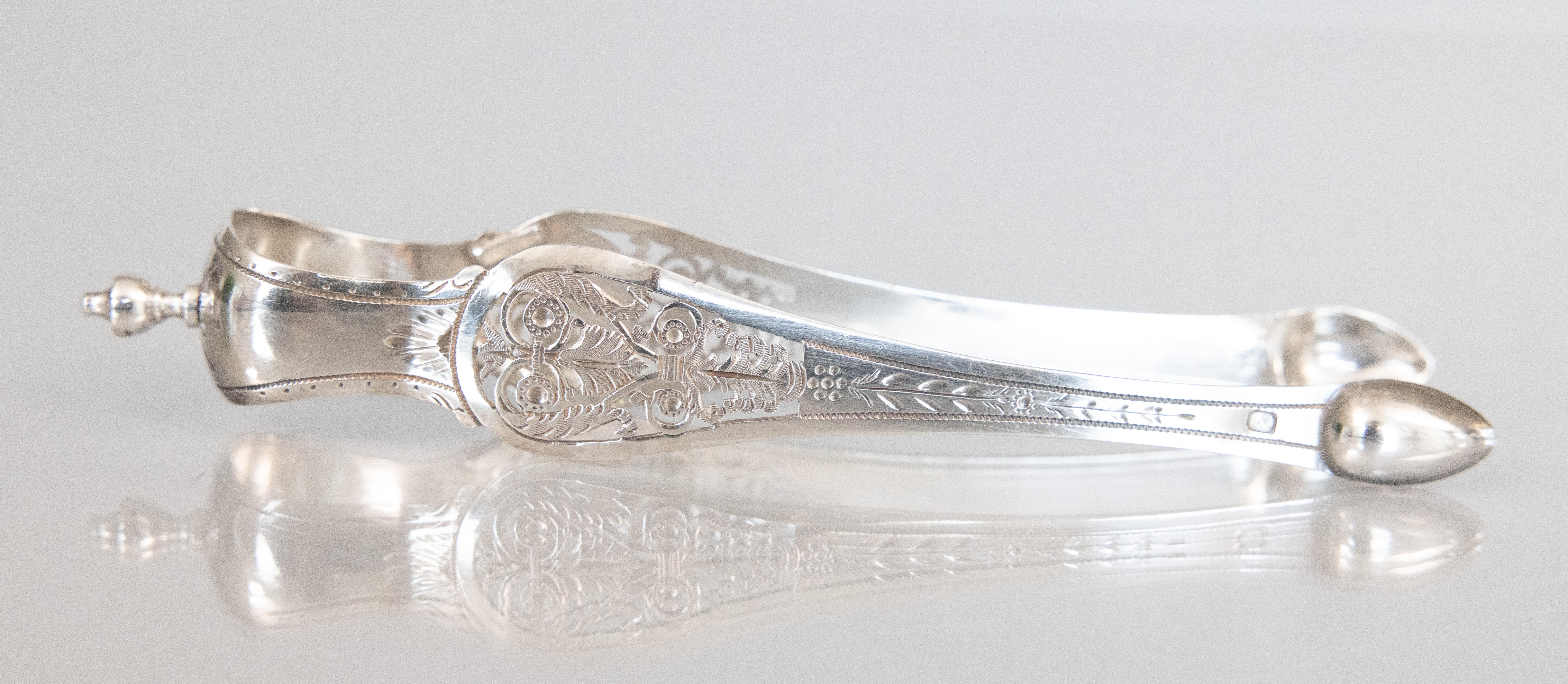 A fine antique French sterling silver pair of sugar tongs with lovely openwork decorations made by Antoine-Adrien Vautrin, Paris, circa 1824-1844. Maker's mark and hallmarks on side. Add the finest French silver to your barware collection or for