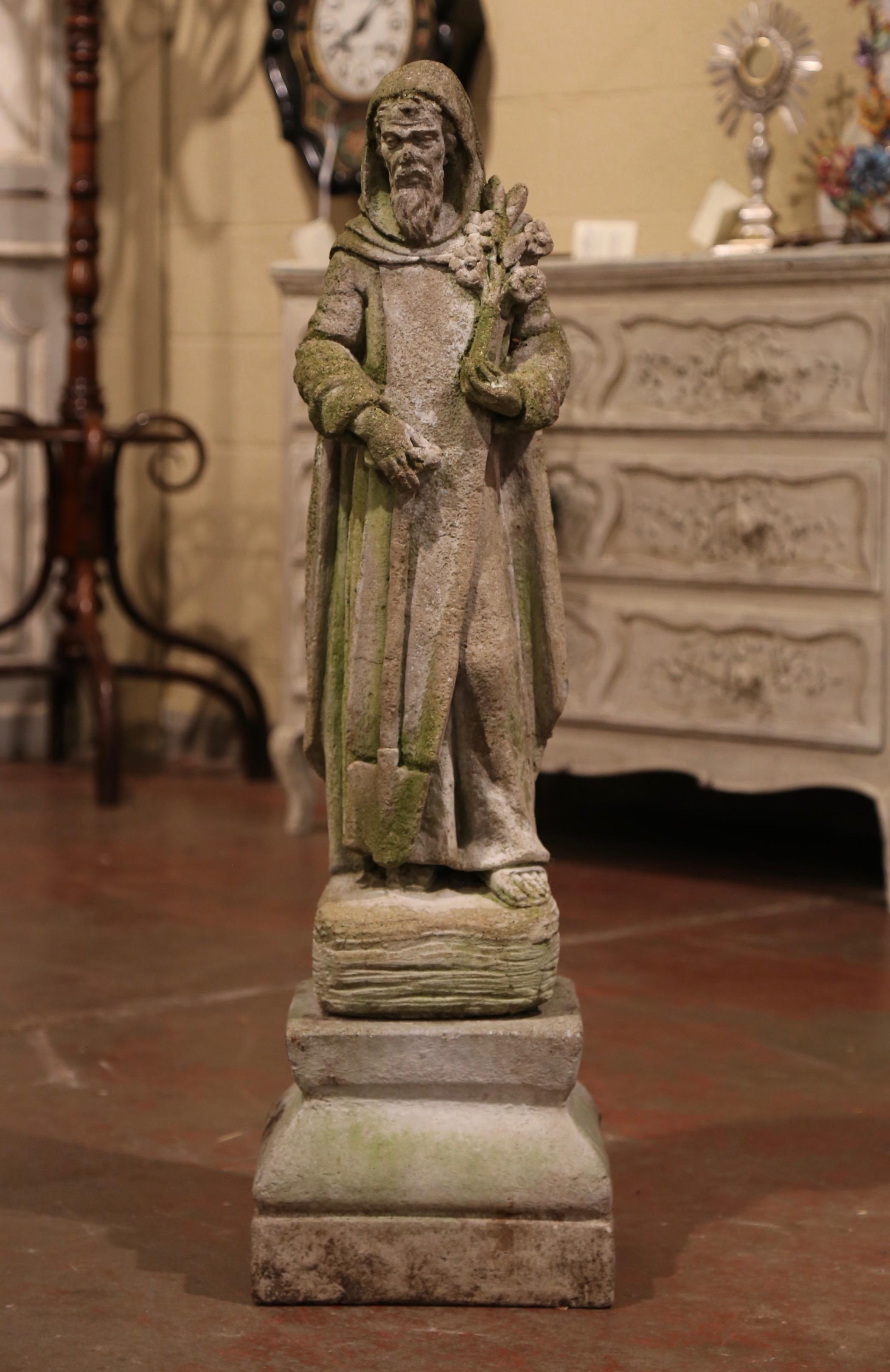 Decorate a garden with this antique statue of Saint Fiacre; crafted in France circa 1850, the statue stands on a rectangular base and features the Saint holding a bouquet of flowers and a shovel in his right hand. The statue is in excellent