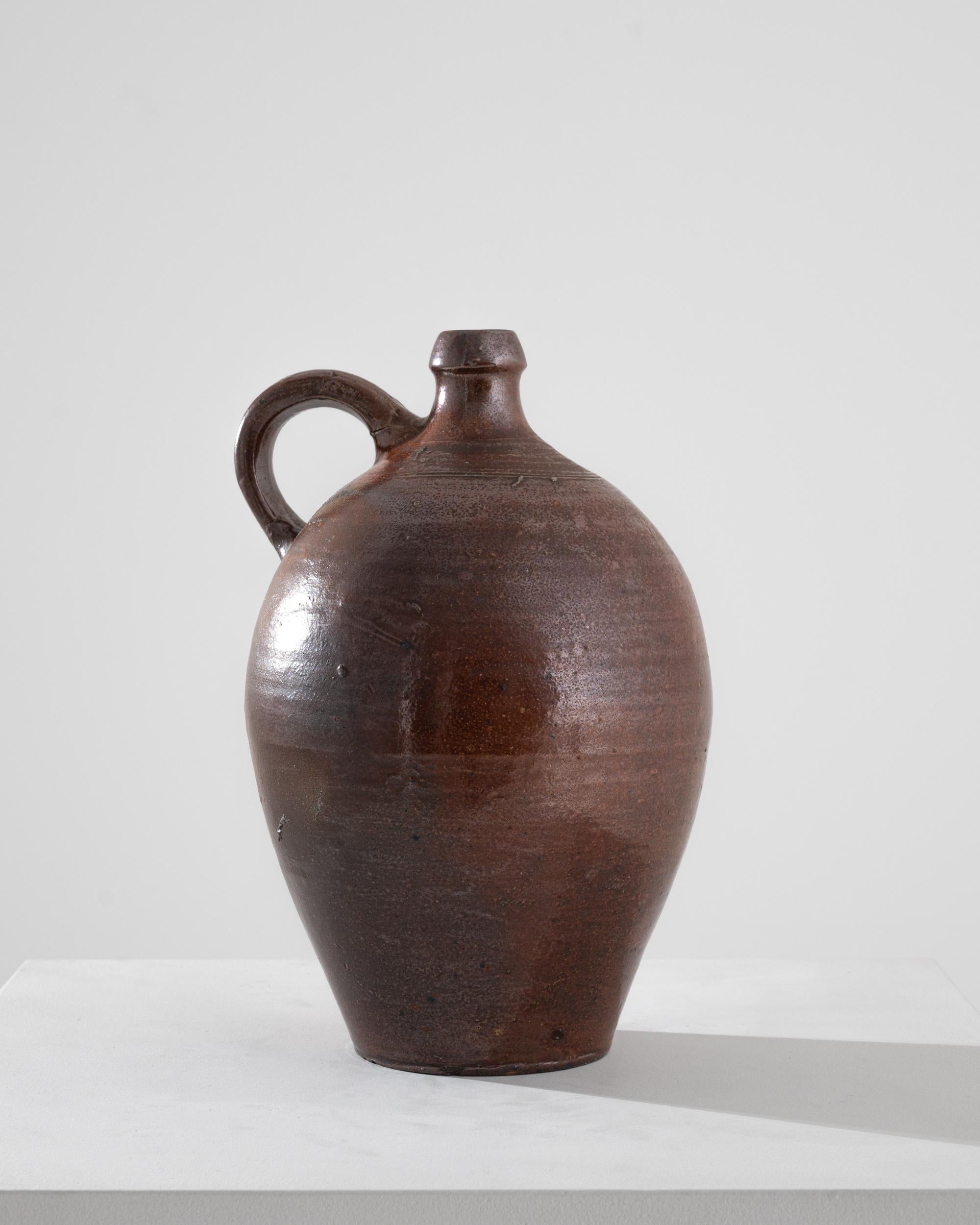 This antique stoneware flagon makes a delightful rustic accent. Made in France in the 1800s, the ceramic was fired at extremely high temperatures, granting it the durability and longevity of stone. These bottles were often originally used to store