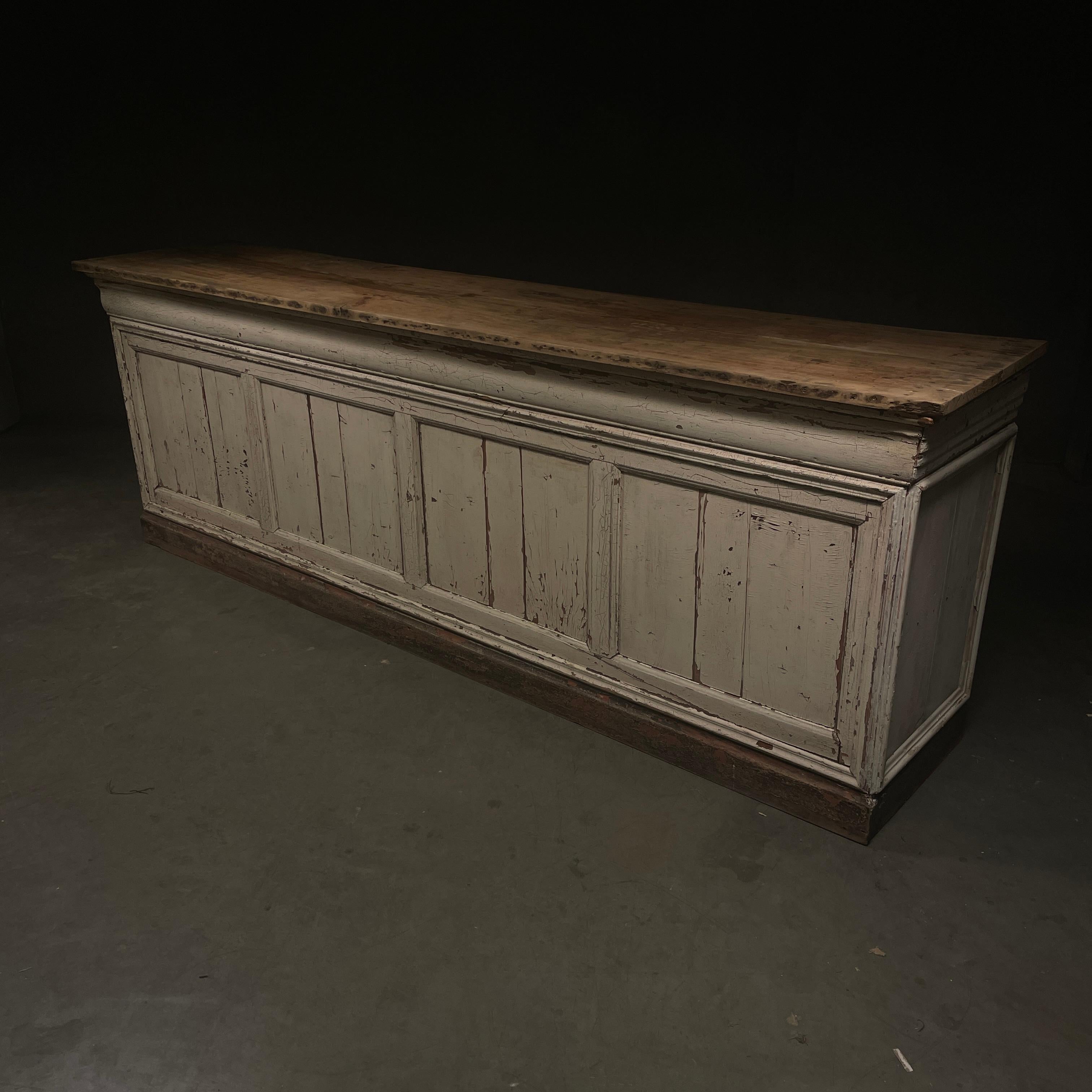 a rare raw example of a general store counter salvaged in the south  of France , featuring multi panels , age cracked original polychrome painted surface,  open storage with one shelf, and a scrubbed original hard wood top.

 We left it dry and