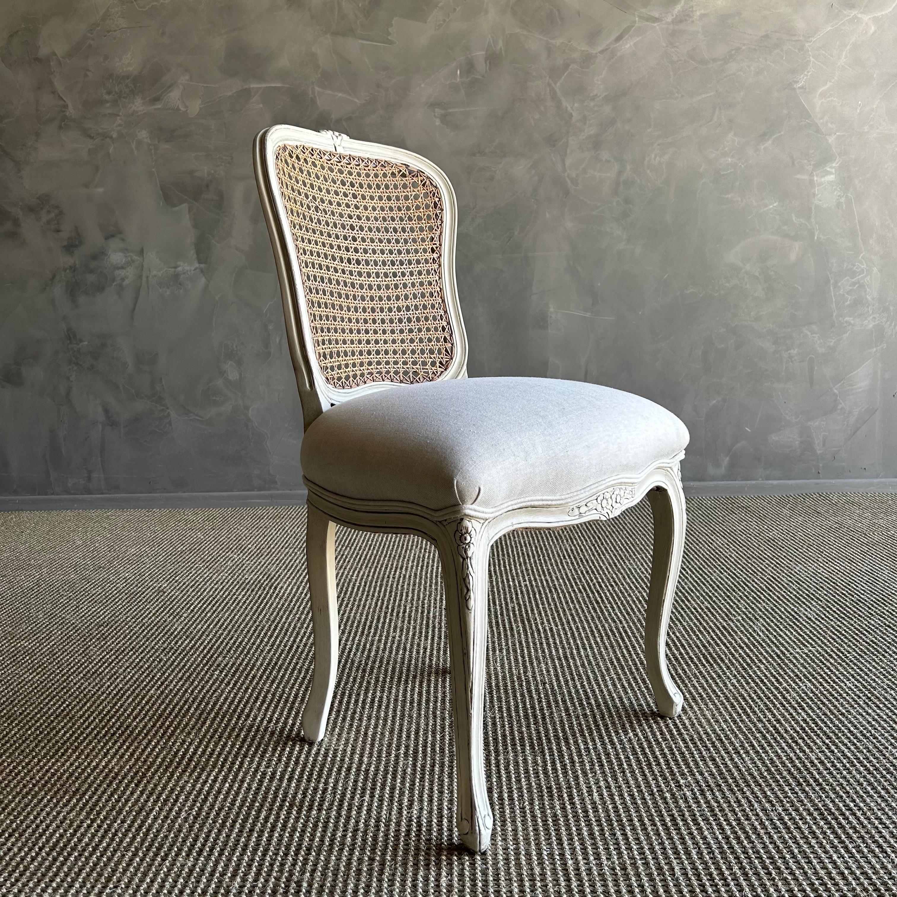 19th century French cane chair crafted from solid fruitwood and painted in a charming oyster white finish. This chair is not only visually stunning but also robust and dependable, perfect for daily use. Whether you are looking for a chic addition to