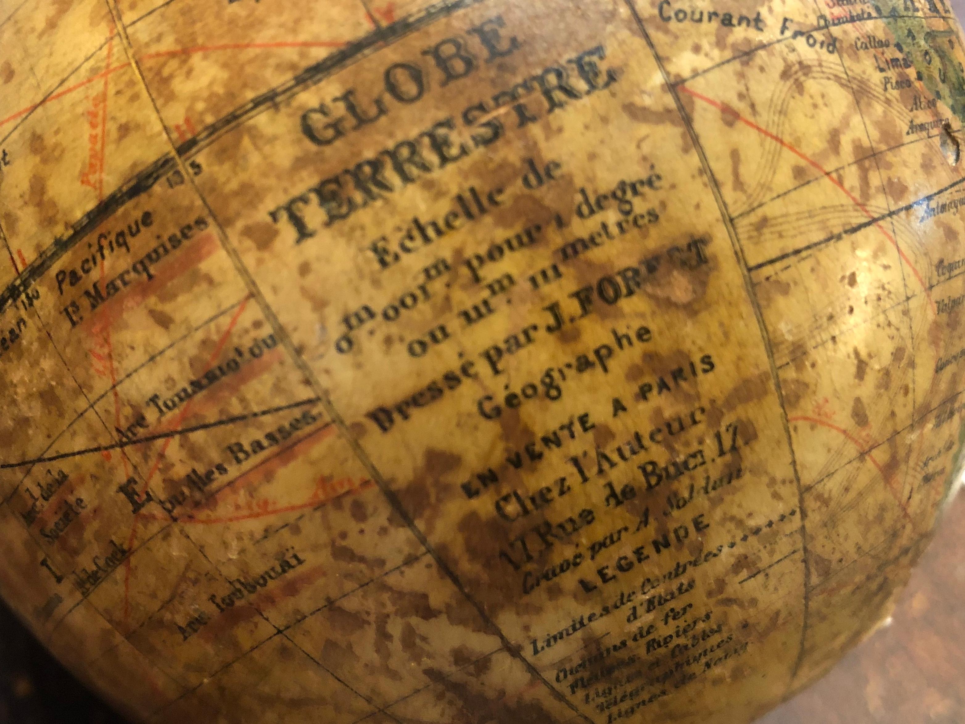 A well proportioned paper, plaster terrestrial globe standing on a turned ebonized base. GLOBE TERRESTRE

