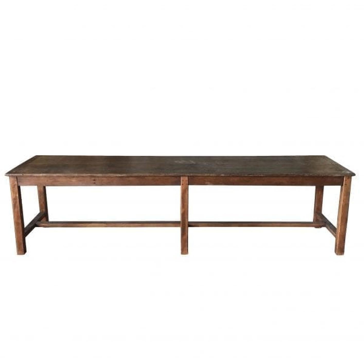 A very long narrow antique French wooden table with six legs, in good condition. This table has an additional extended top pull out and is made of hand carved, dark walnut with a waxed finish. Wear consistent with age and use, circa 1890, France.