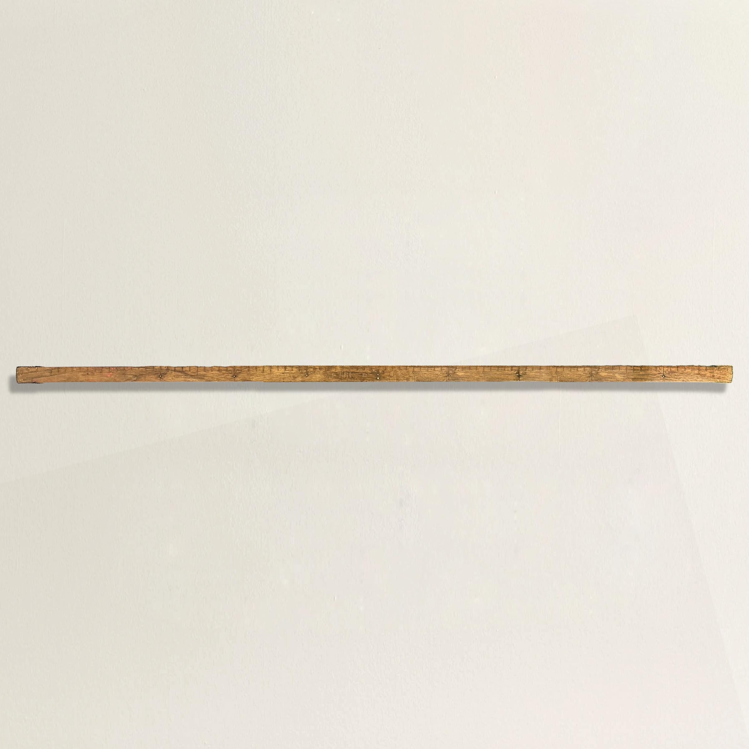 Dating back to the 19th century, this French tailor's maple and brass measuring meterstick is a rare and special piece from France's famed fashion industry. Used to measure fabrics by the meter in centimeters, this meterstick is marked with