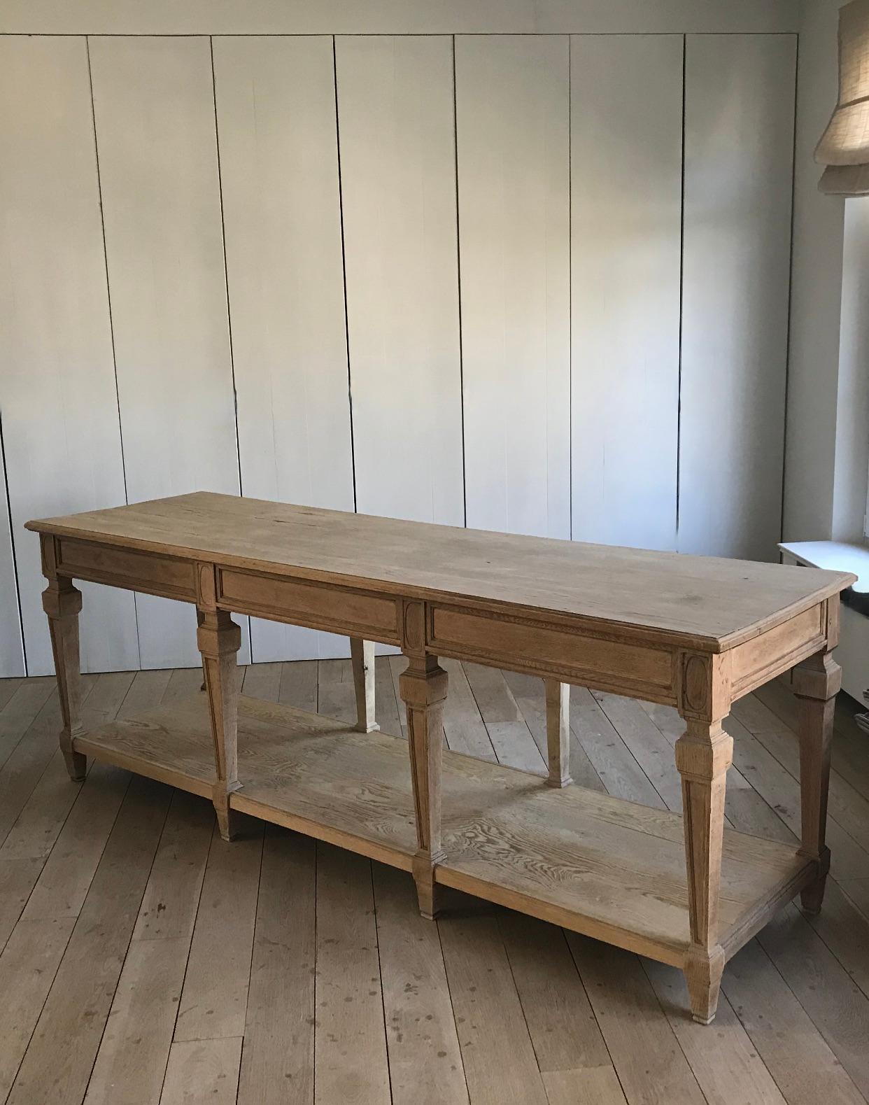 Natural beauty in solid oak wood. 
An impressive 19th century tailor's table in pale and slightly greyed oak.
Nice subtle signs of use due to age.

The bottom tablet makes it very handy for storage. A piece distinguished by its simplicity and