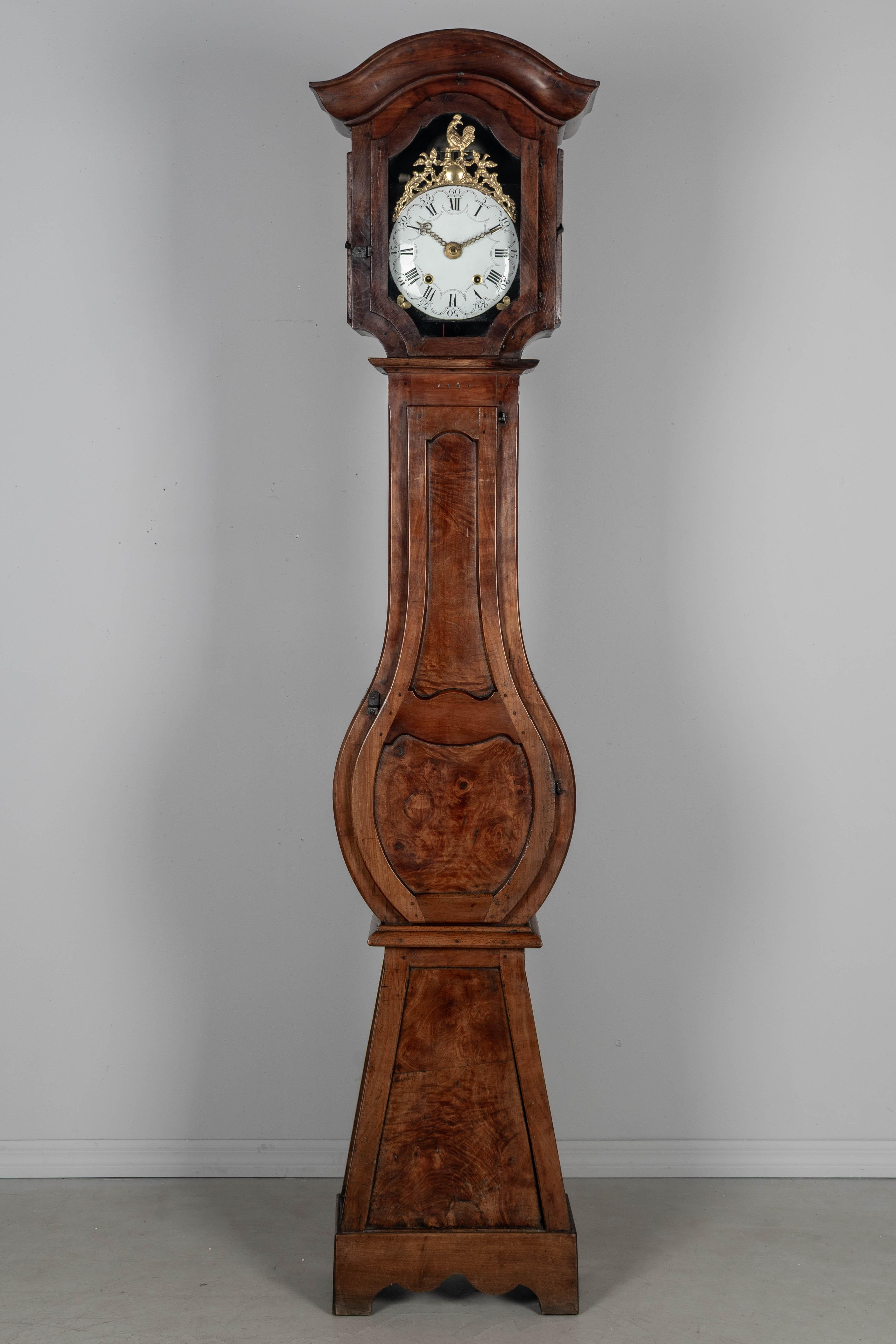 Orologio di campagna francese del XIX secolo in stile Luigi XV, horloge de parquet o orologio a cassa alta proveniente dalla Borgogna. La cassa è realizzata in noce e ciliegio con pannelli in radica di olmo. In due parti, con corpo sagomato e curvo