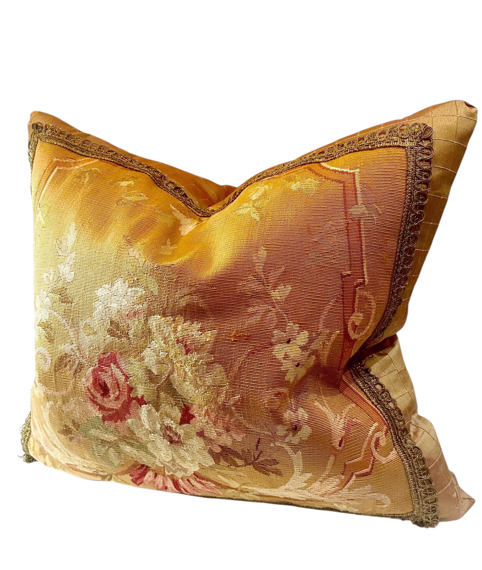 Paire de coussins en tapisserie française datant des années 1860. Chacune présente un panneau frontal tissé de façon complexe dans le style classique du 19e siècle, avec de riches détails et des tons doux et vieillis. Les dos sont finis en soie et
