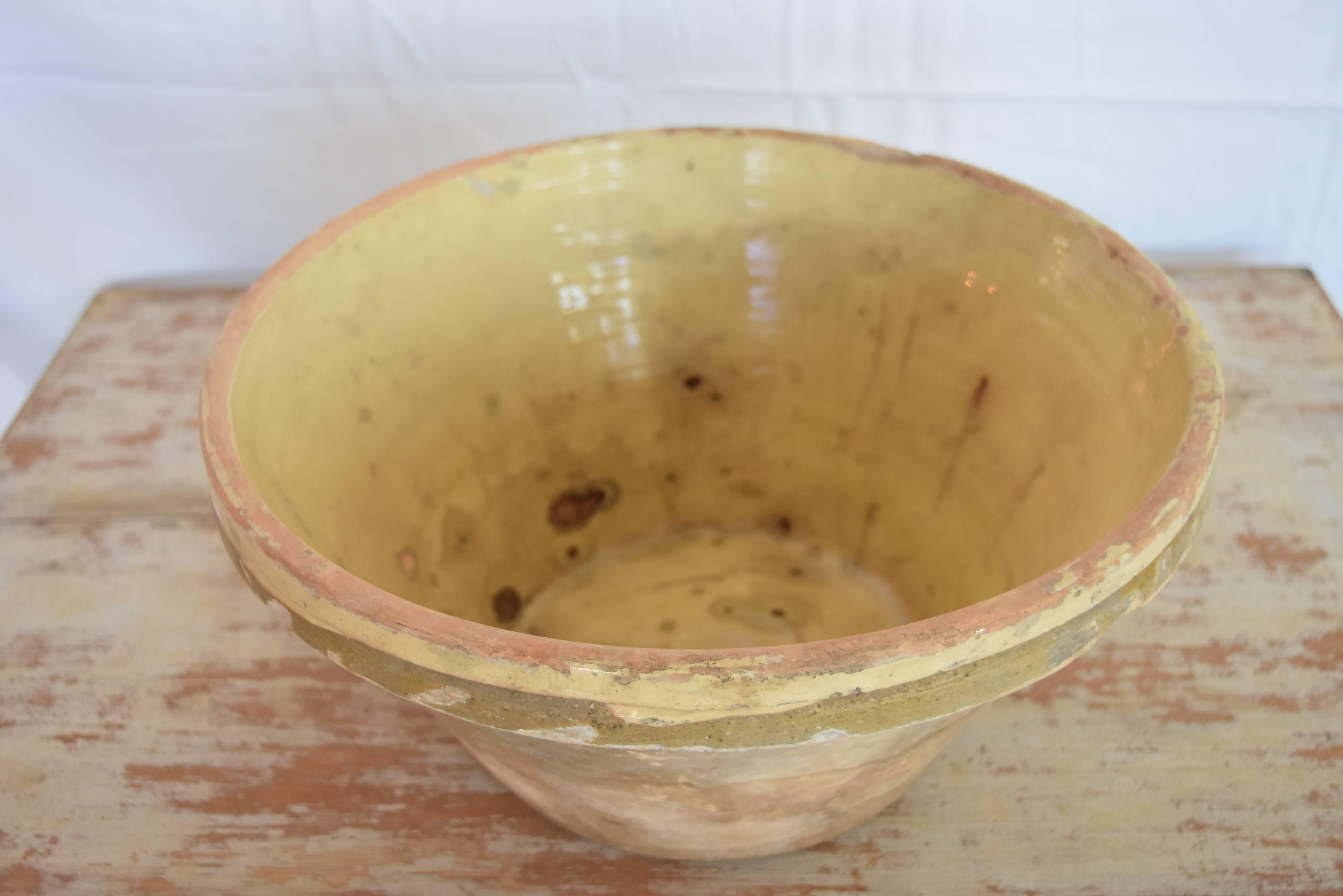 This French bowl is from the South of France where beautiful pottery is produced. This one is very light pale yellow on cream base and show lots of use and age. It does have a hairline crack at the bottom of the glaze buy you can see it doesn't go
