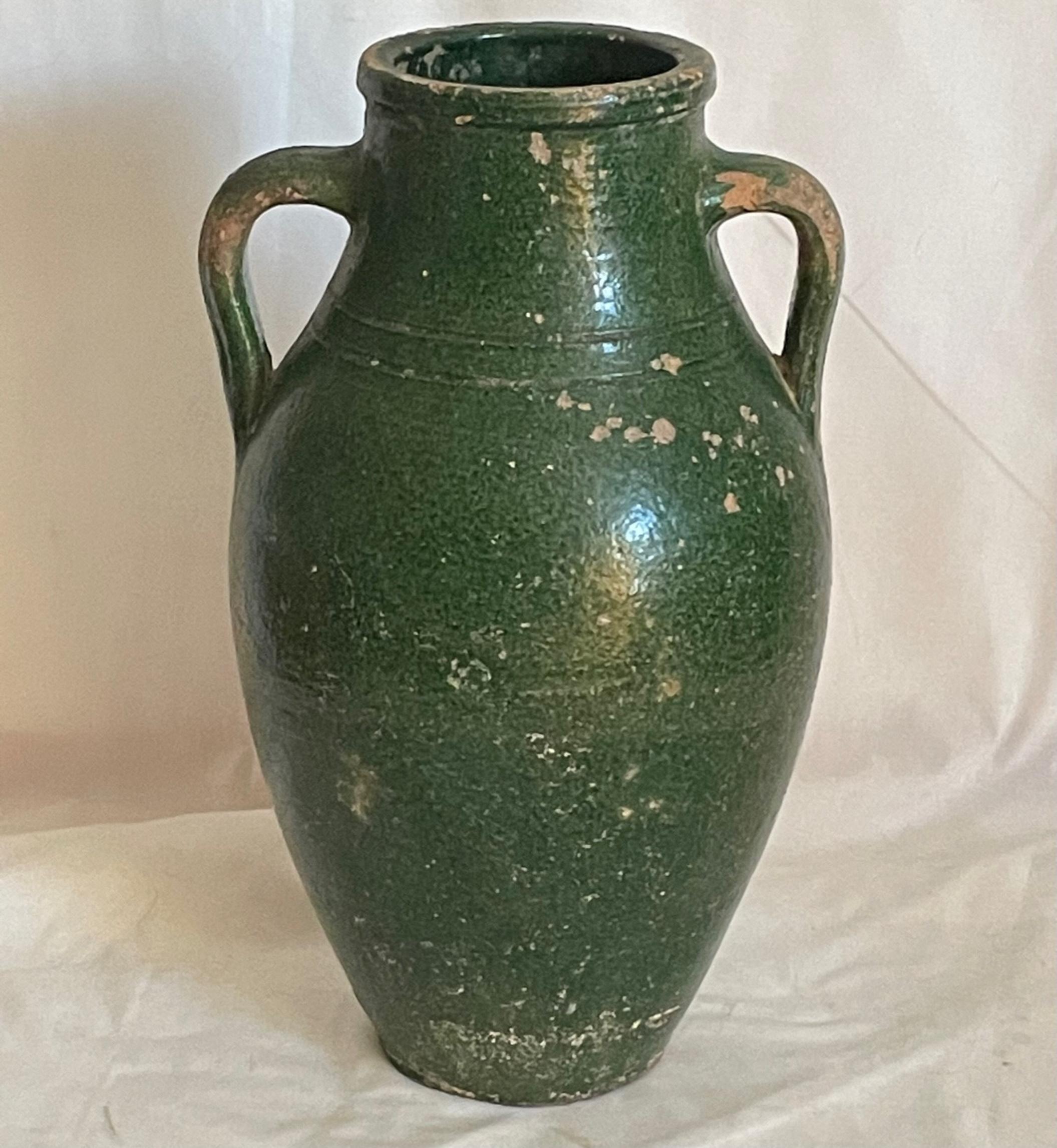 19th Century French Terracotta Amphora olive jar.

French provincial double handle amphora vessel with green glaze from the 19th century. The terracotta jug features a green glazed body with a nicely distressed patina. Probably created for the