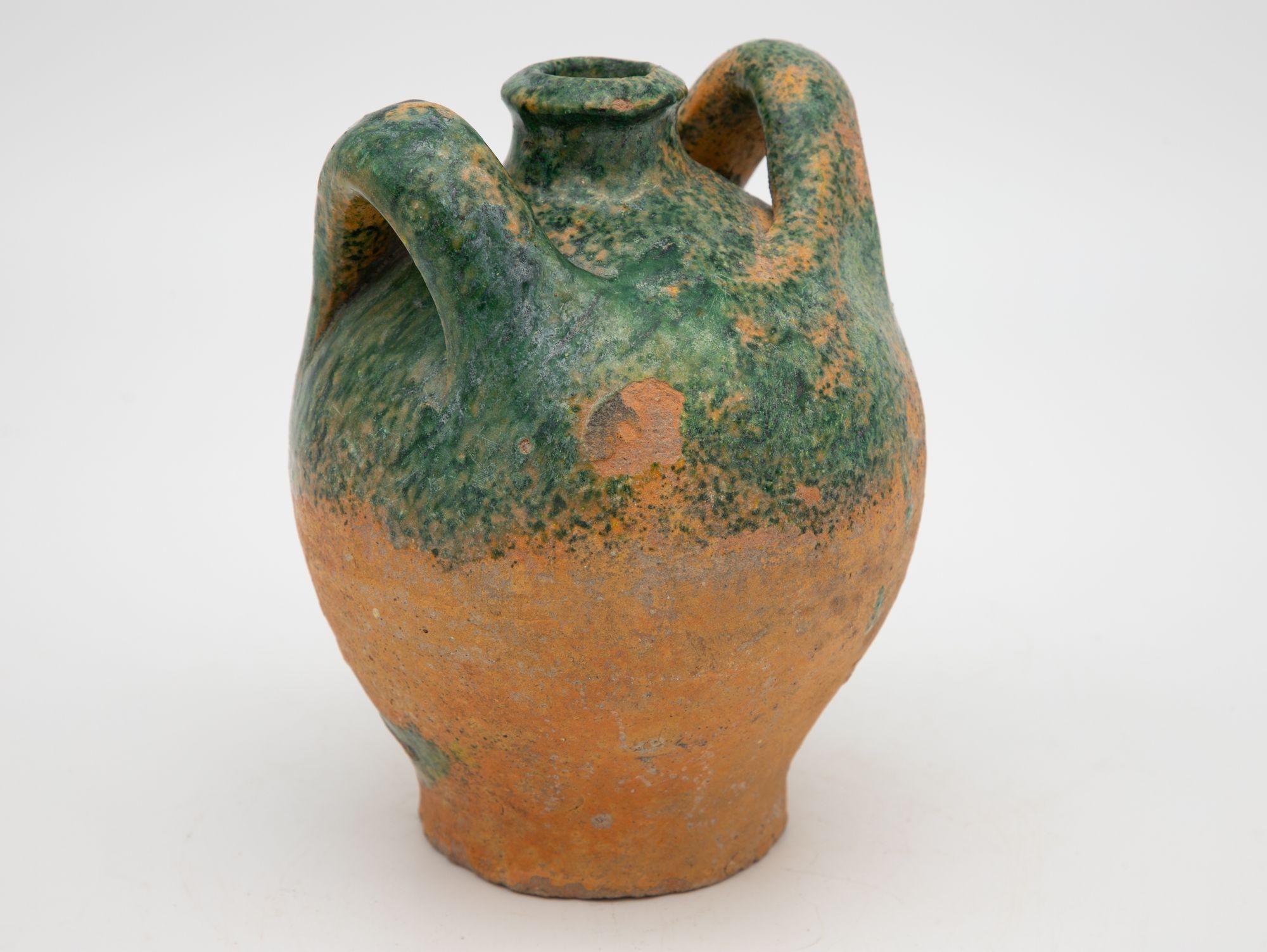 A late 19th century terracotta confit pot from Southwest France. The pot has its original cork and shows two handles with a traditional green glaze. Wear consistent for age and use.