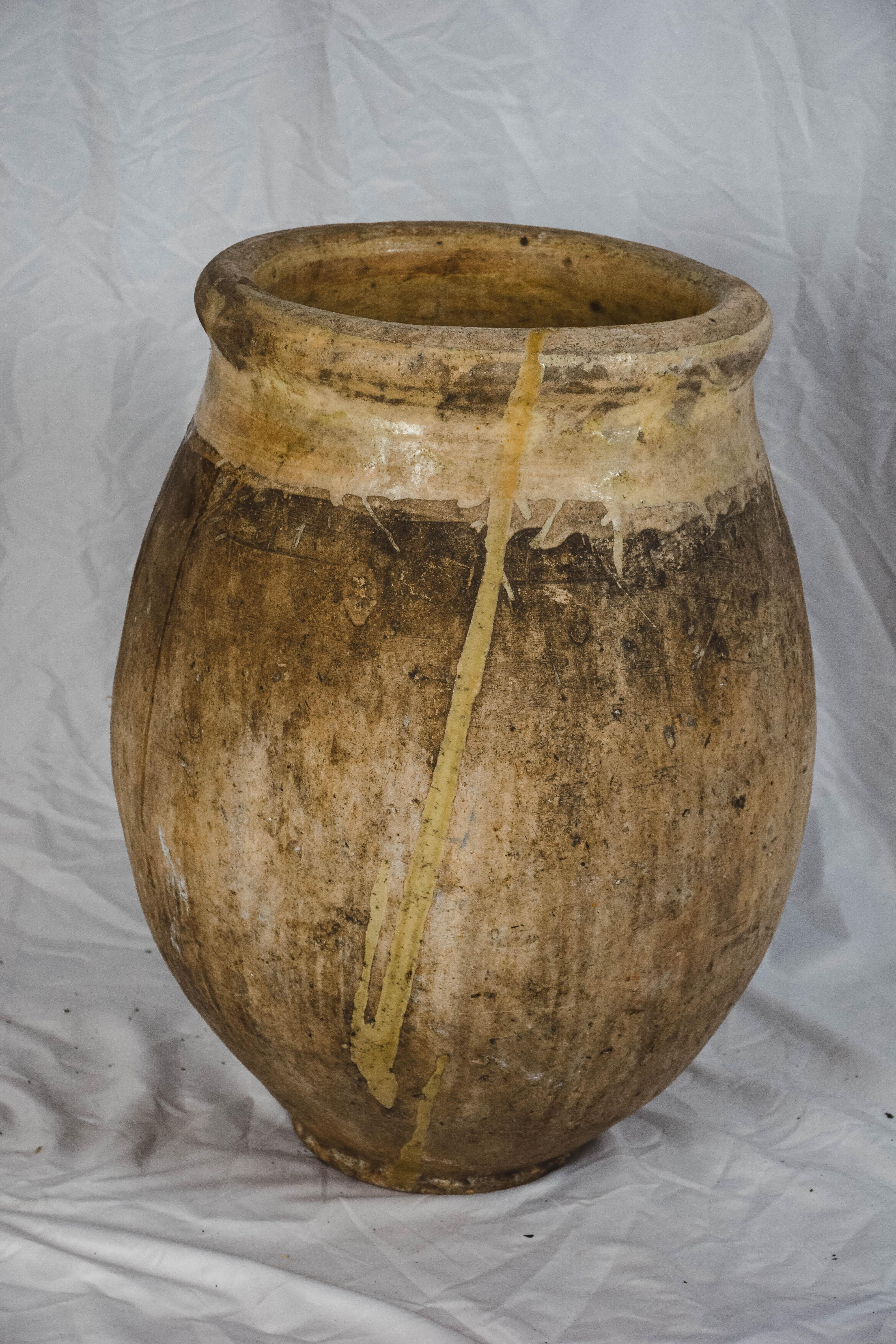 Found in Provence this 19th century French Biot Jar in traditional Biot shape has a lovely aged patina and pale yellow-glazed rolled edge and interior. This fabulous handmade terracotta jar originated in the Provençal town of Biot and was used to