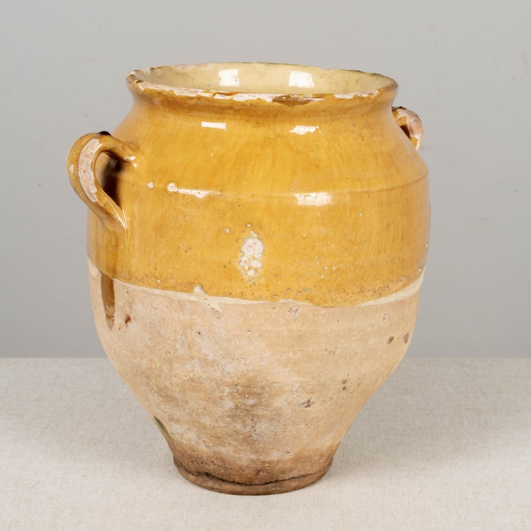 A 19th century earthenware confit pot from the Southwest of France with traditional yellow glaze. Chips, cracks and losses to glaze. These ordinary earthenware vessels were once used daily in the French country home and have beautiful rustic glazes
